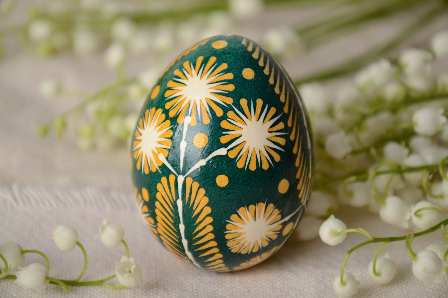Green and yellow handmade painted Easter egg ornamented using waxing technique photo 1