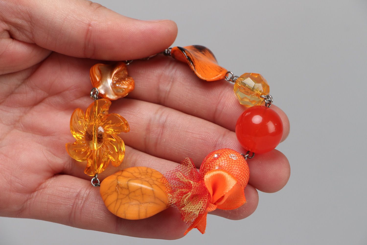 Bright handmade wrist bracelet with orange plastic beads of different shapes photo 3