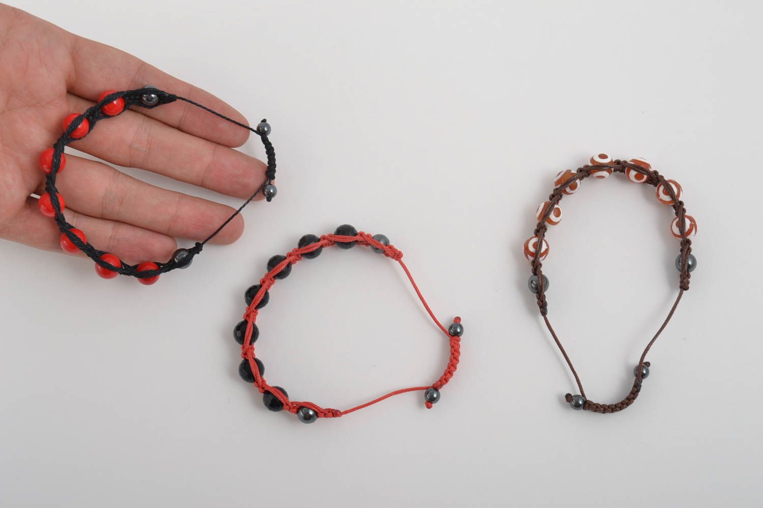 Set of three strand bracelets on red, brown, black cords with red, black, white, and brown beads for women photo 5