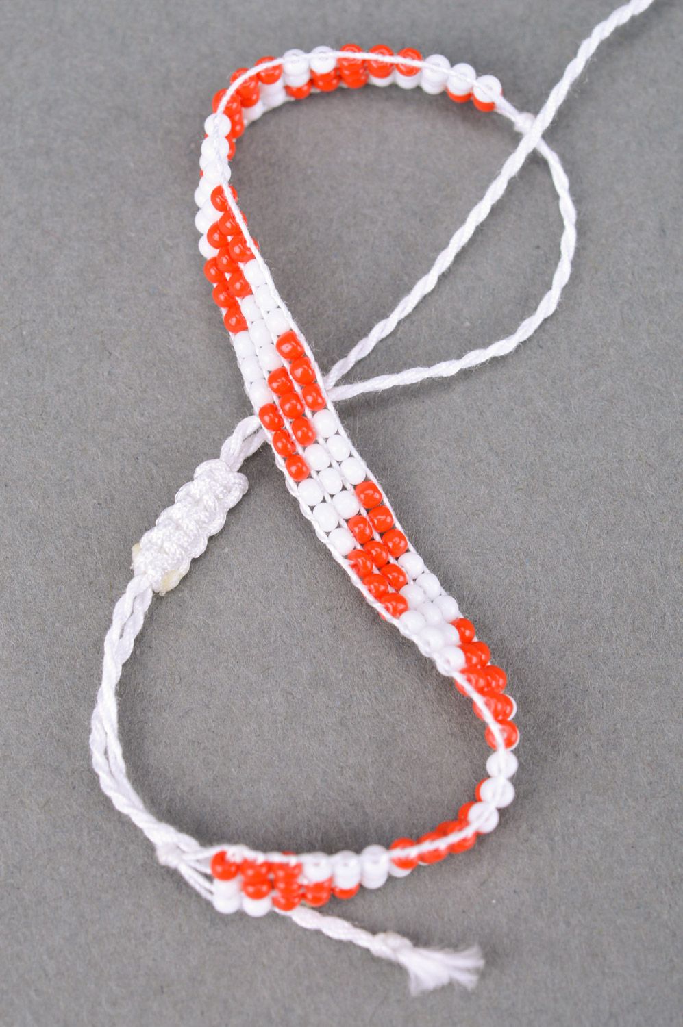 Плетеный браслет на руку из бисера ручной работы красный с белым тонкий фото 5