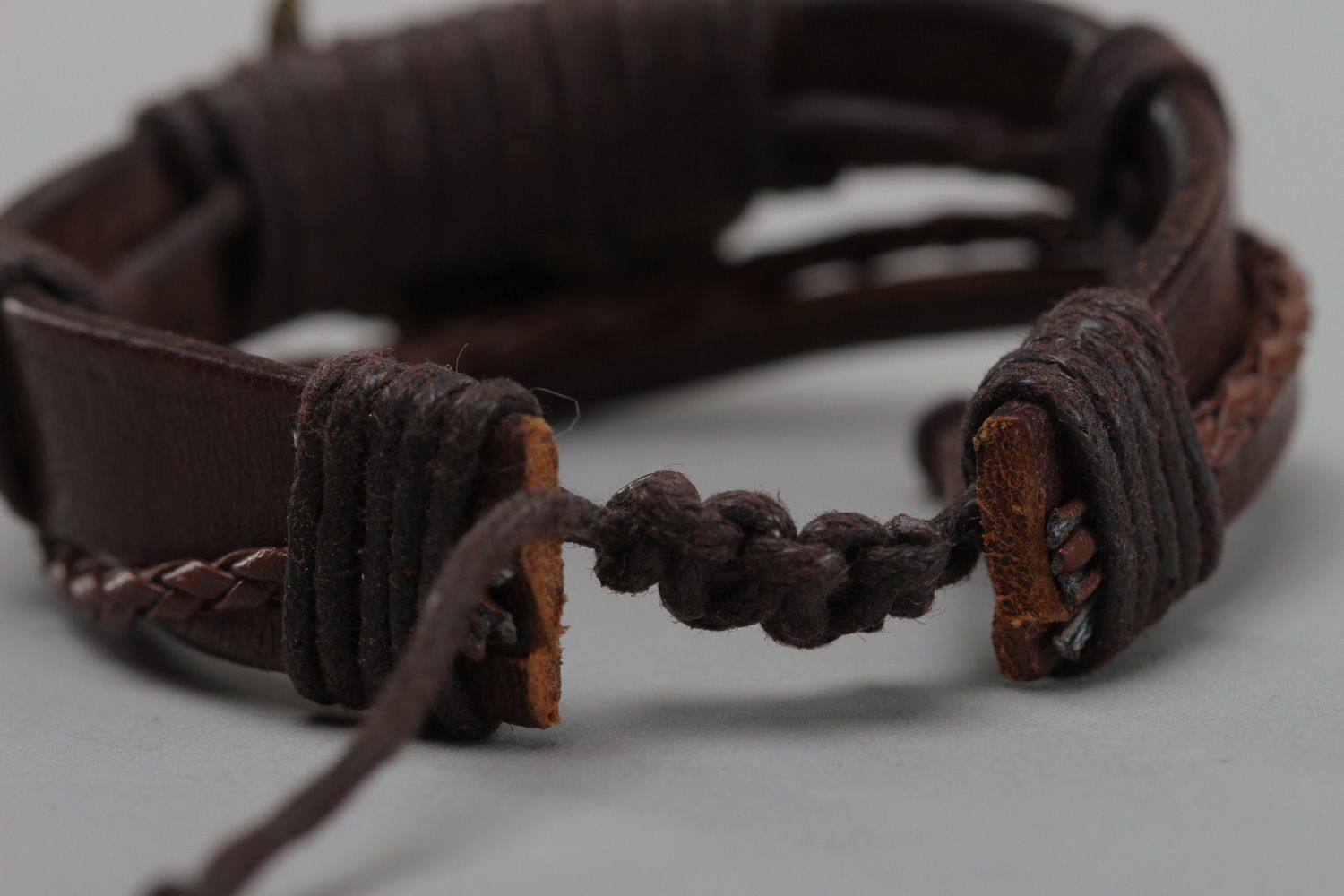 Dark brown handmade wrist bracelet woven of genuine leather with metal wings photo 4