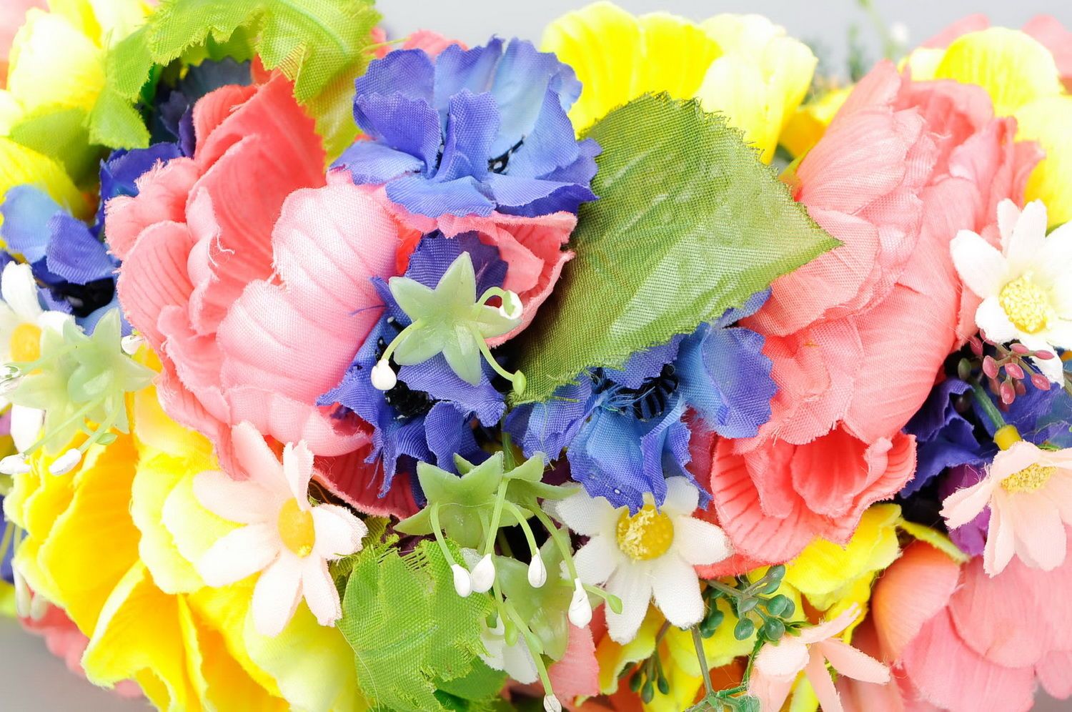 Bright wreath with artificial flowers and ribbons photo 4