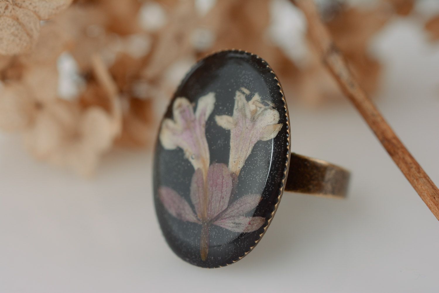 Handmade black oval ring with natural flower coated with epoxy resin for women photo 1