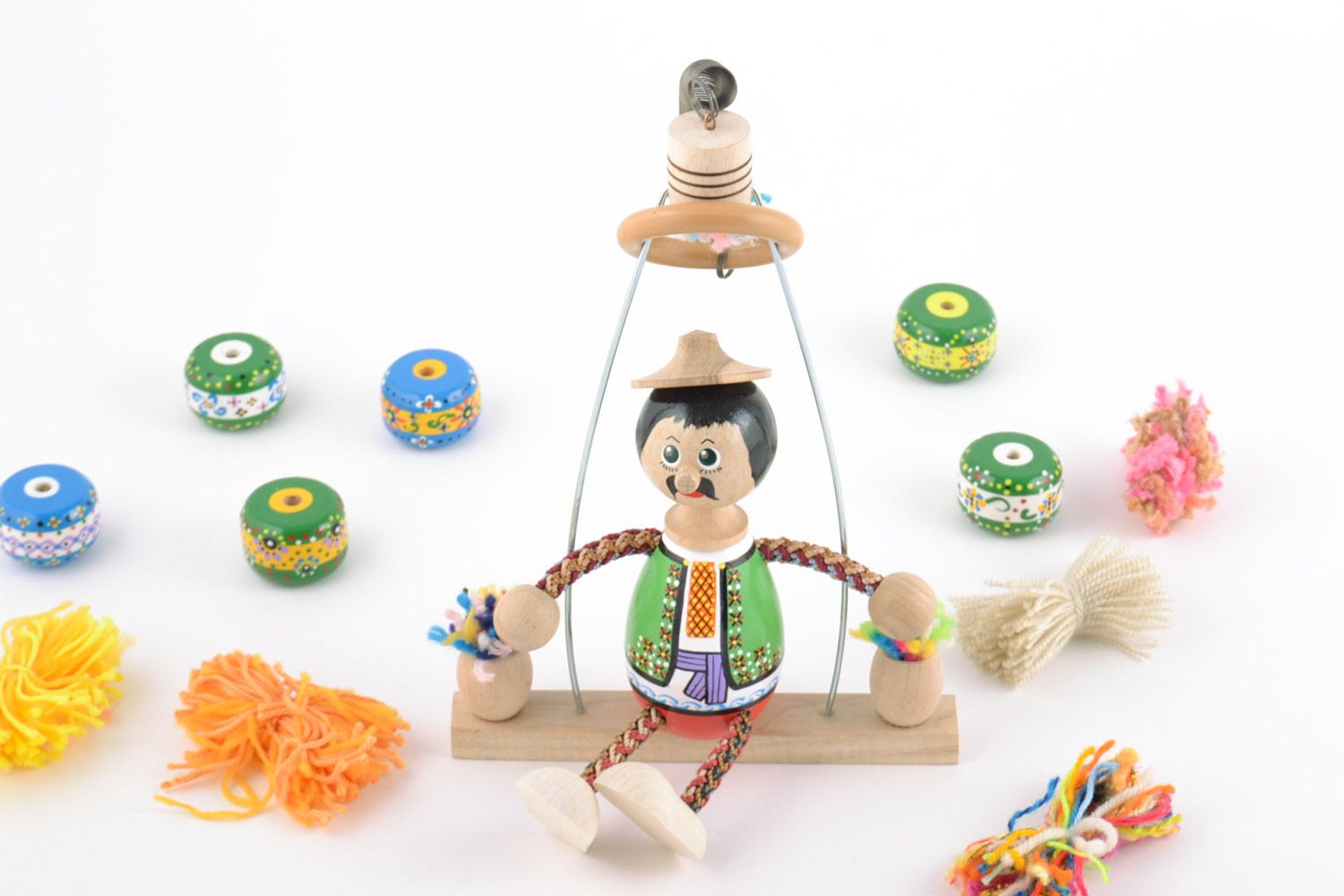 Handmade bemaltes buntes Öko Spielzeug aus Holz mit Feder Junge auf Schaukel foto 1