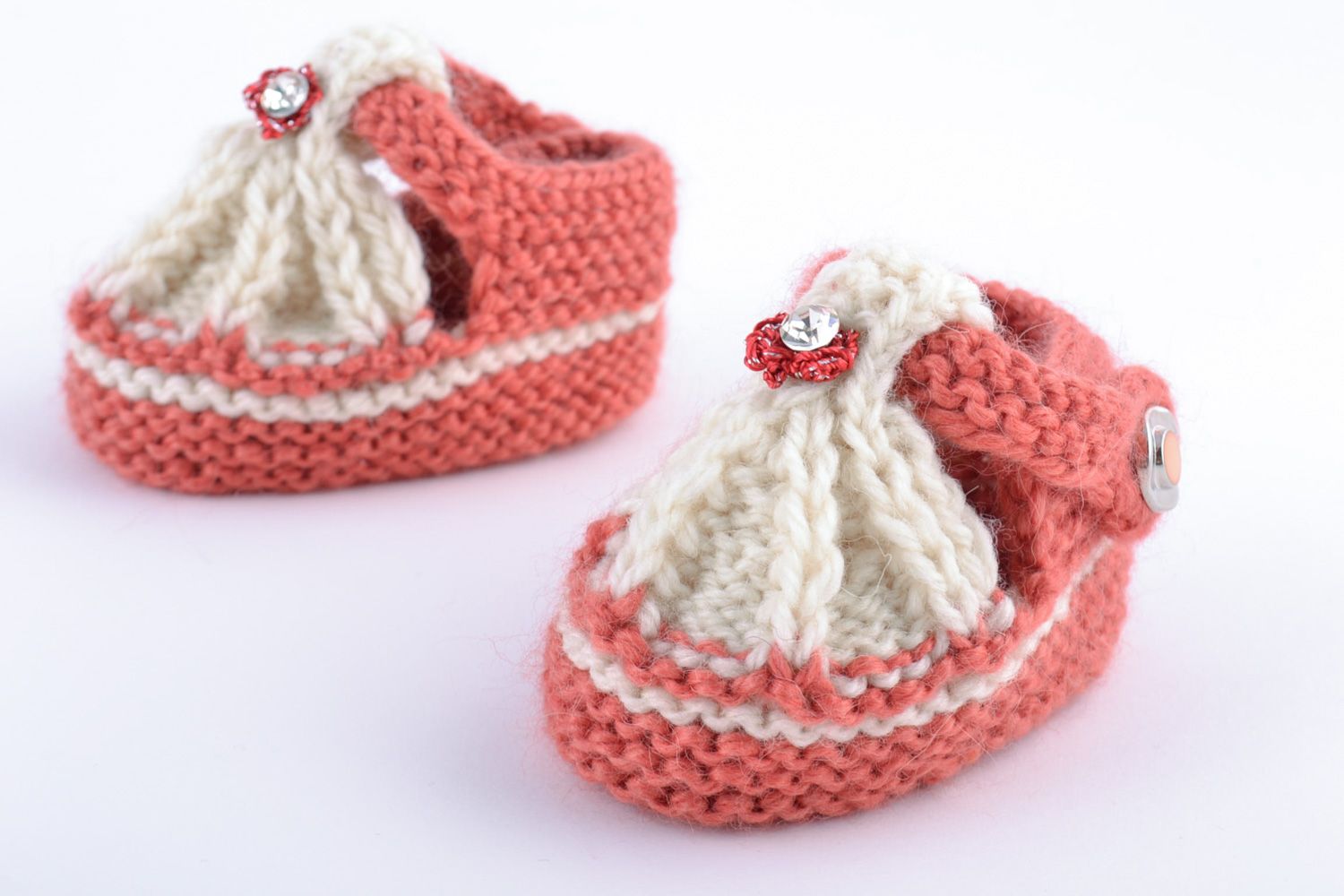 Helle weiße und rosafarbige handgemachte Babyschuhe aus Wolle in Form von Sandalen foto 4