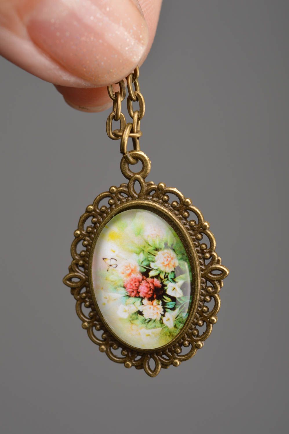 Colgante metálico ovalado con cabujón con flores y cadena larga artesanal foto 3