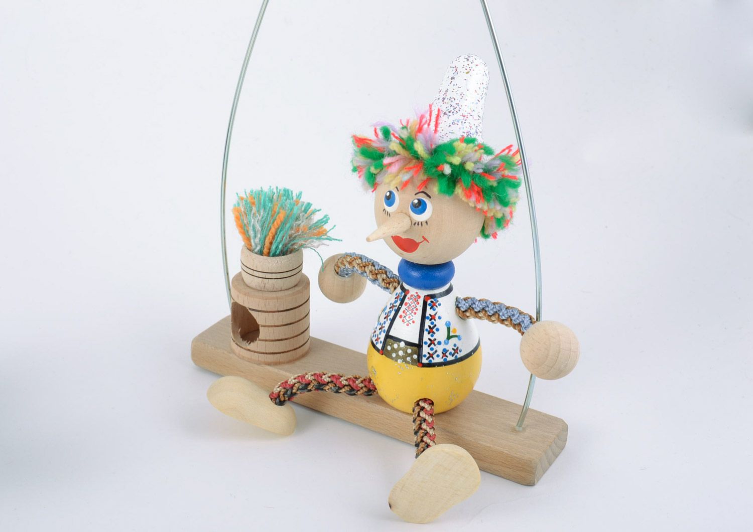 Helles schönes originelles handgemachtes Öko Spielzeug aus Holz Junge auf Bank  foto 4