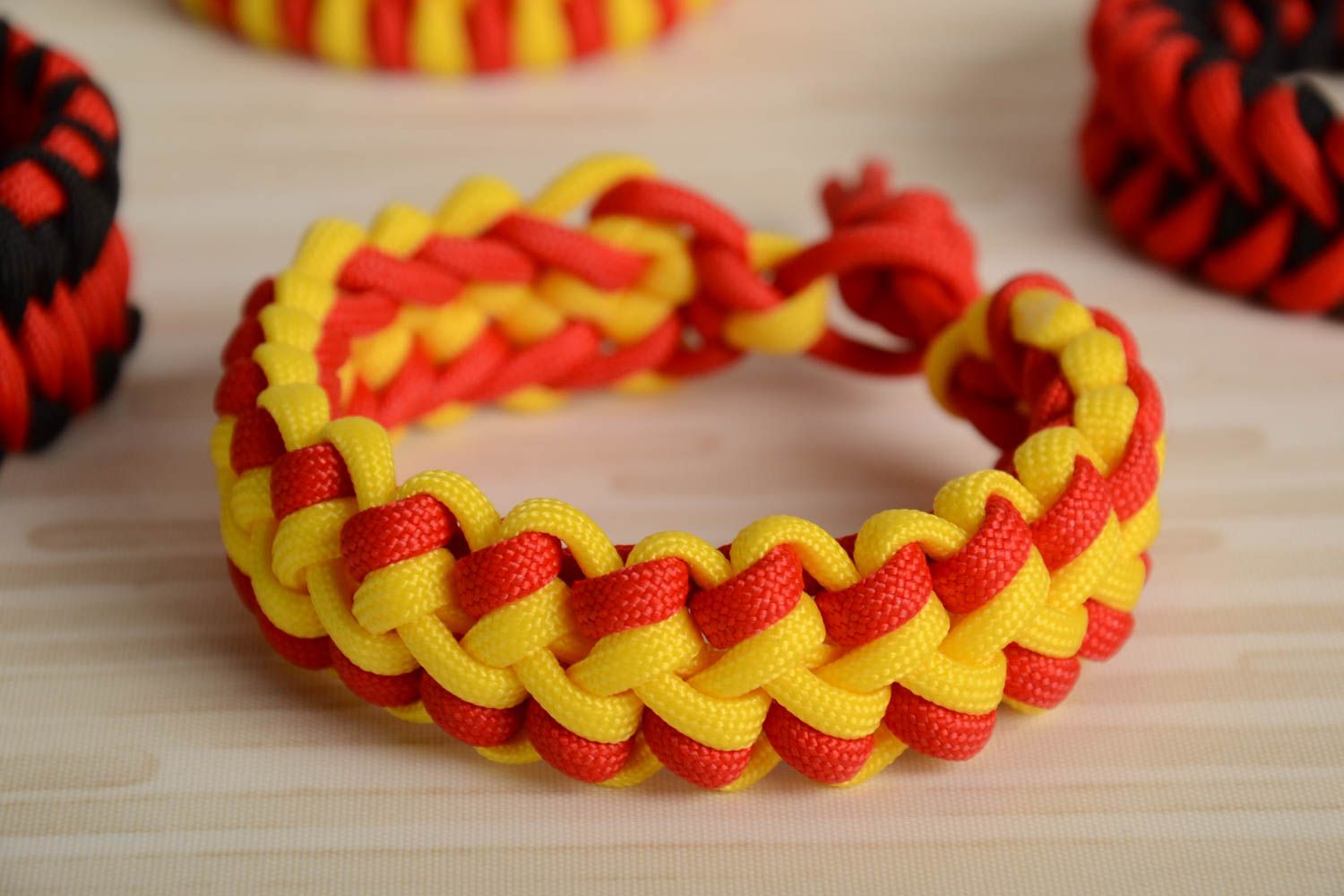Red and yellow handmade wrist bracelet woven of American paracord photo 1