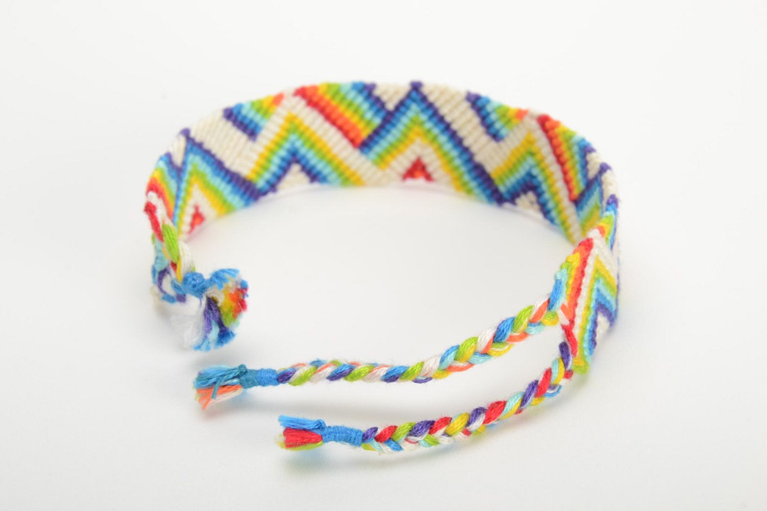 Handmade friendship bracelet woven of threads with rainbow colored ornament photo 3