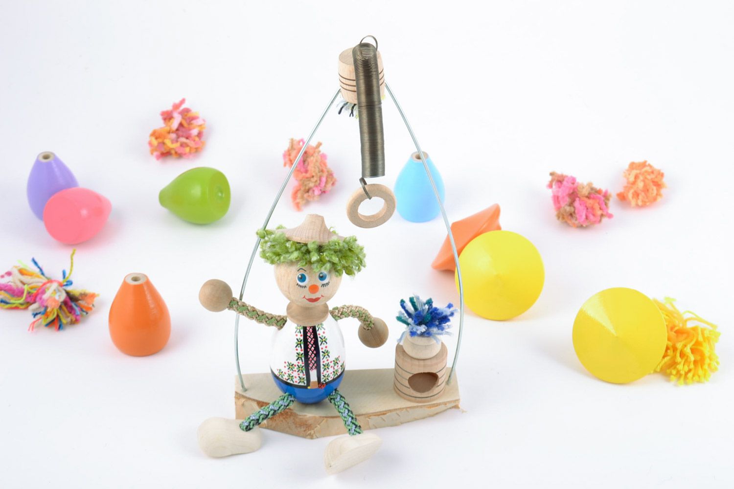Homemade painted wooden eco toy in the shape of boy on swing for children photo 1