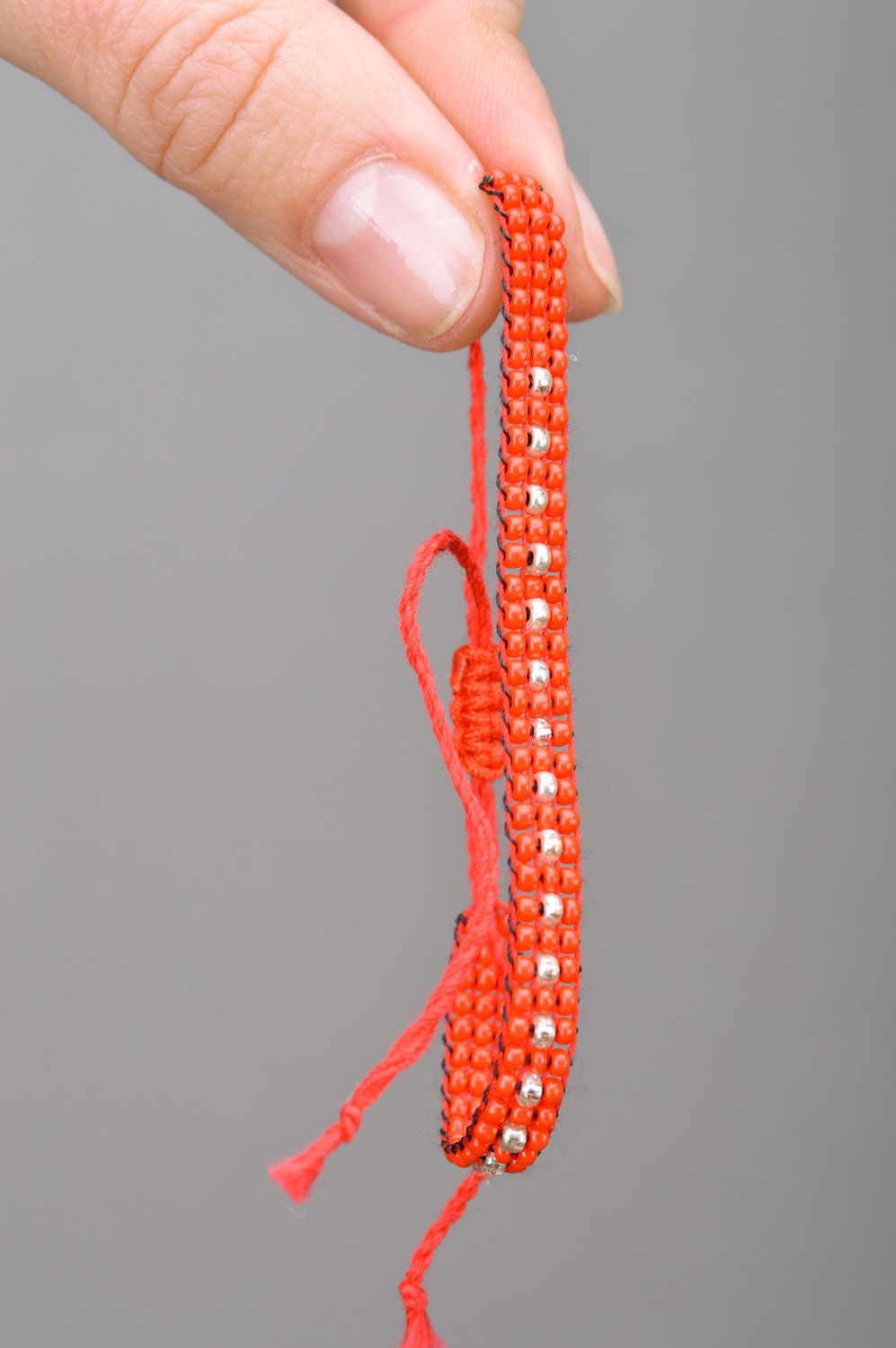 Узкий браслет на руку из бисера на завязках ручной работы красный с серебряным фото 3