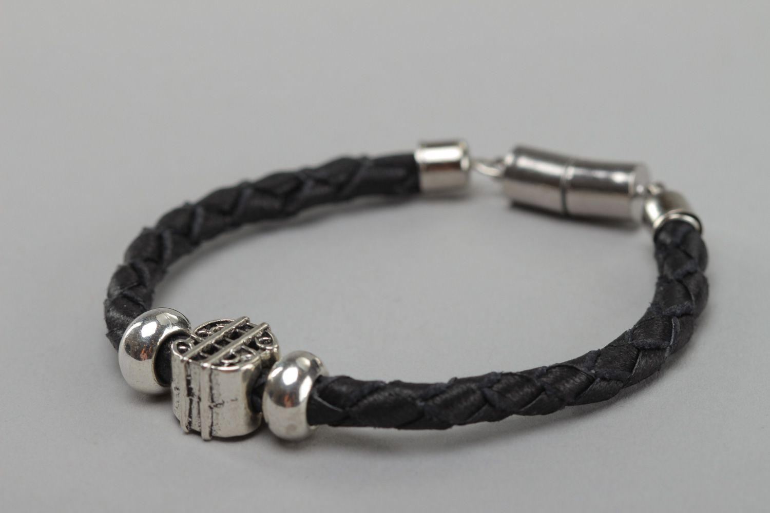 Thin black handmade wrist bracelet woven of genuine leather with metal inserts photo 3