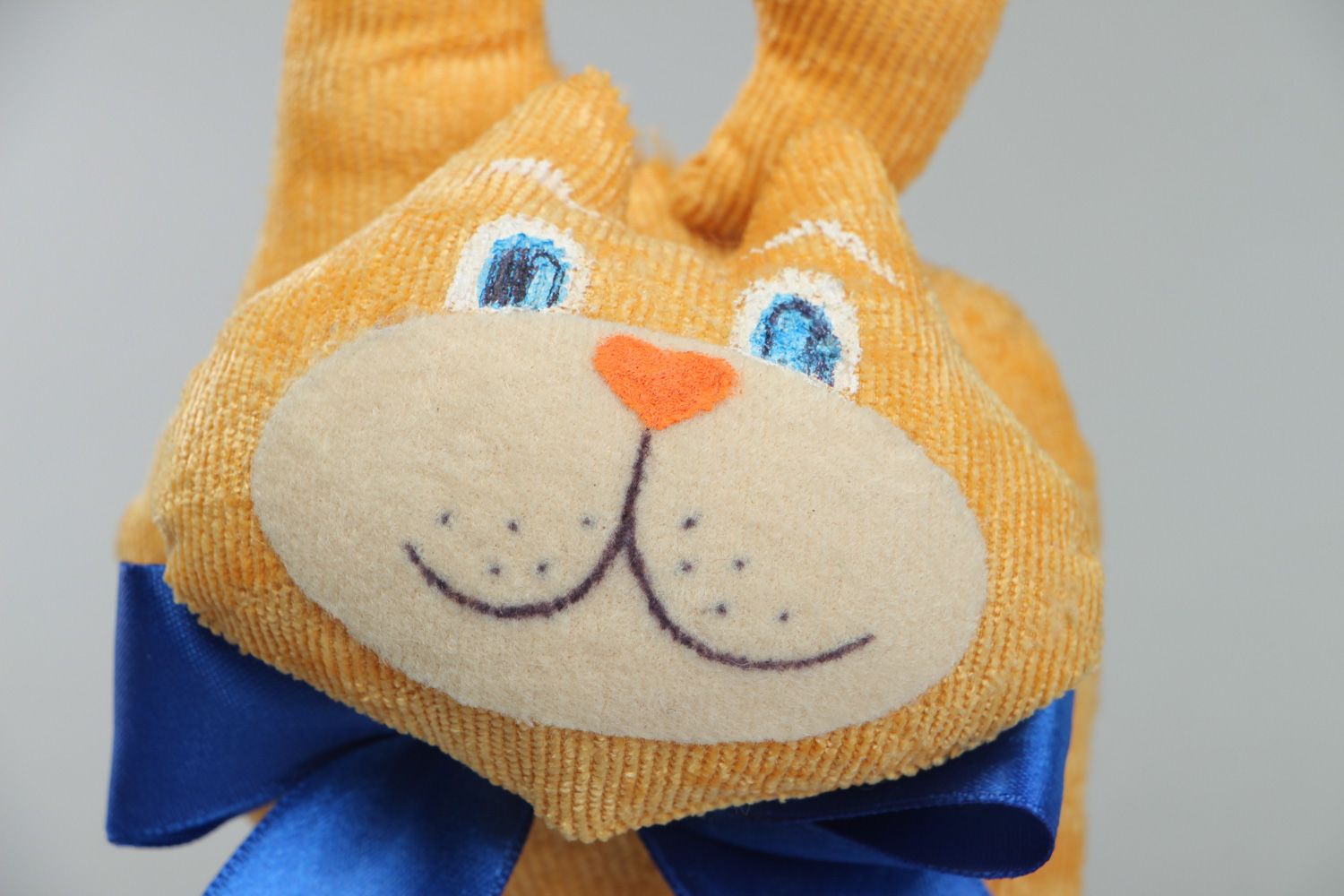 Cute handmade soft toy in the shape of yellow cat with blue bow for children photo 2