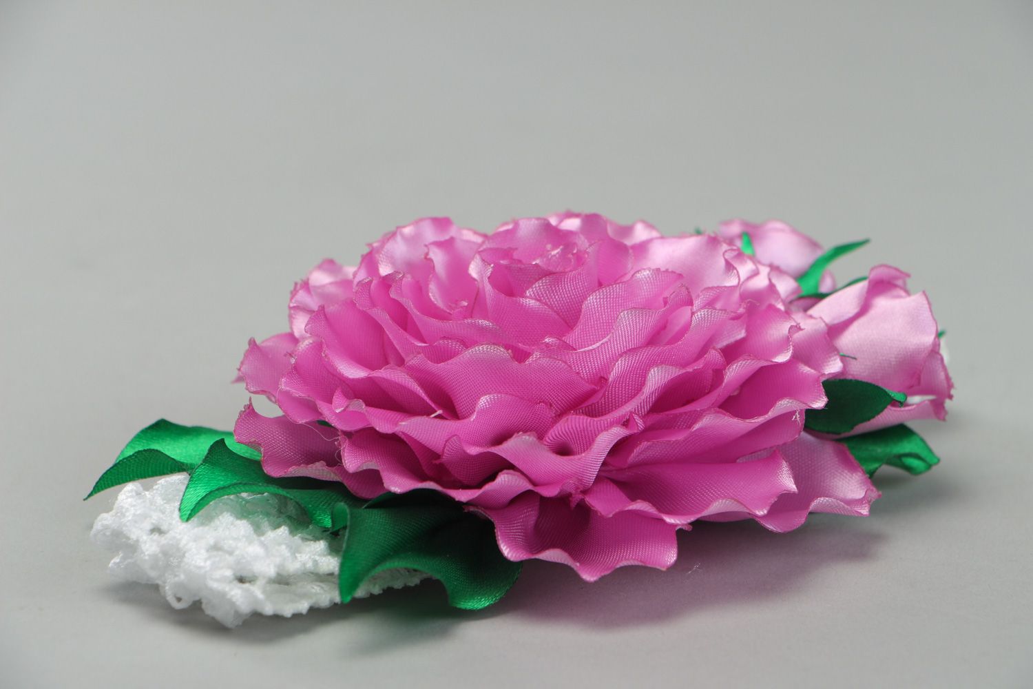 Bright elastic handmade headband with satin flower of pink color with green leaves photo 2
