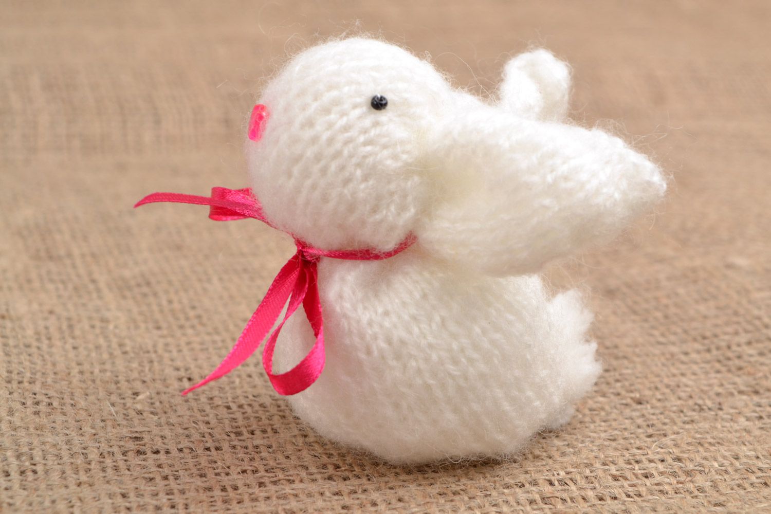 Handmade soft toy knitted of angora wool in the shape of white rabbit with pink bow photo 1