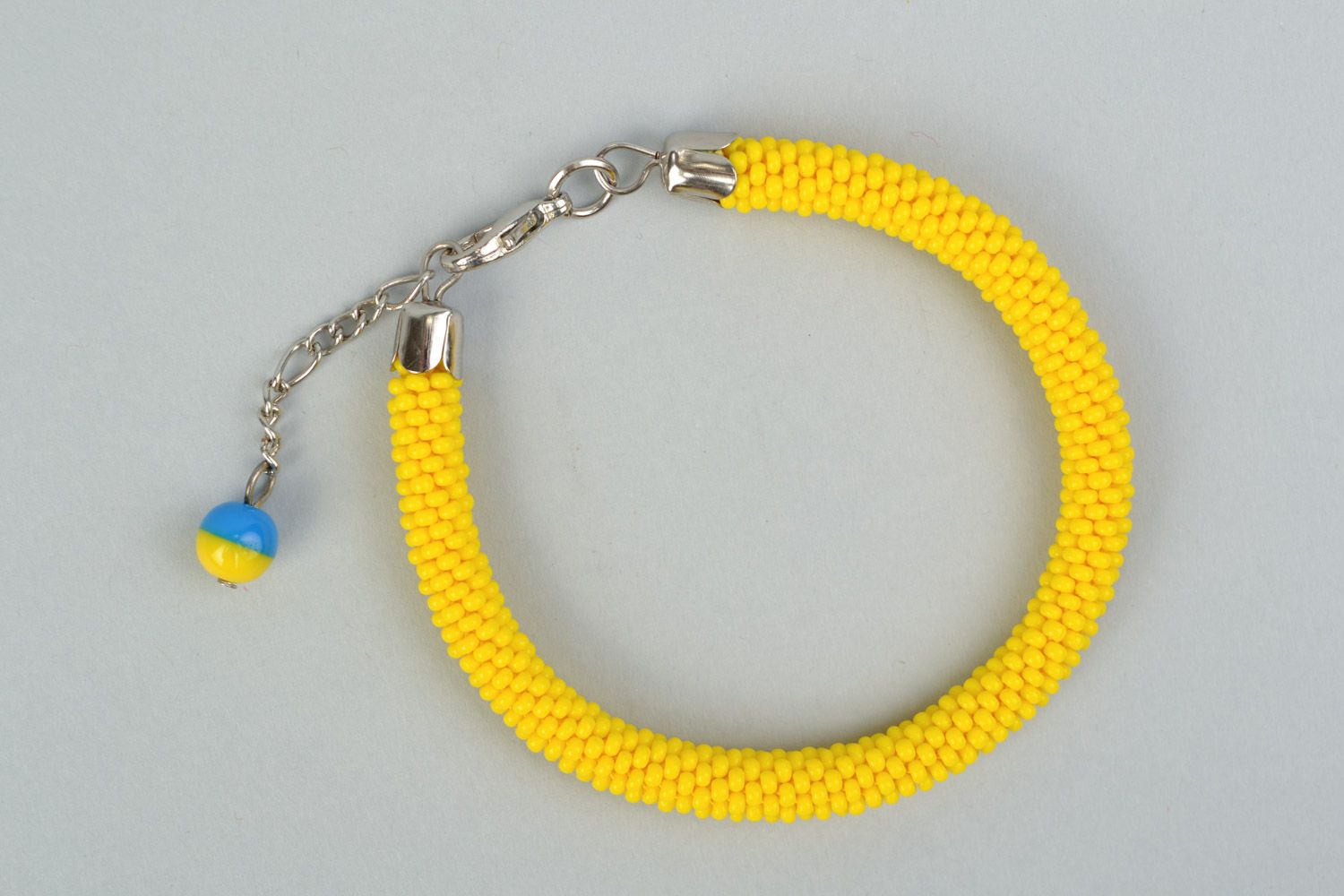 Handmade cord bracelet crocheted of bright yellow Czech beads with blue charm photo 4