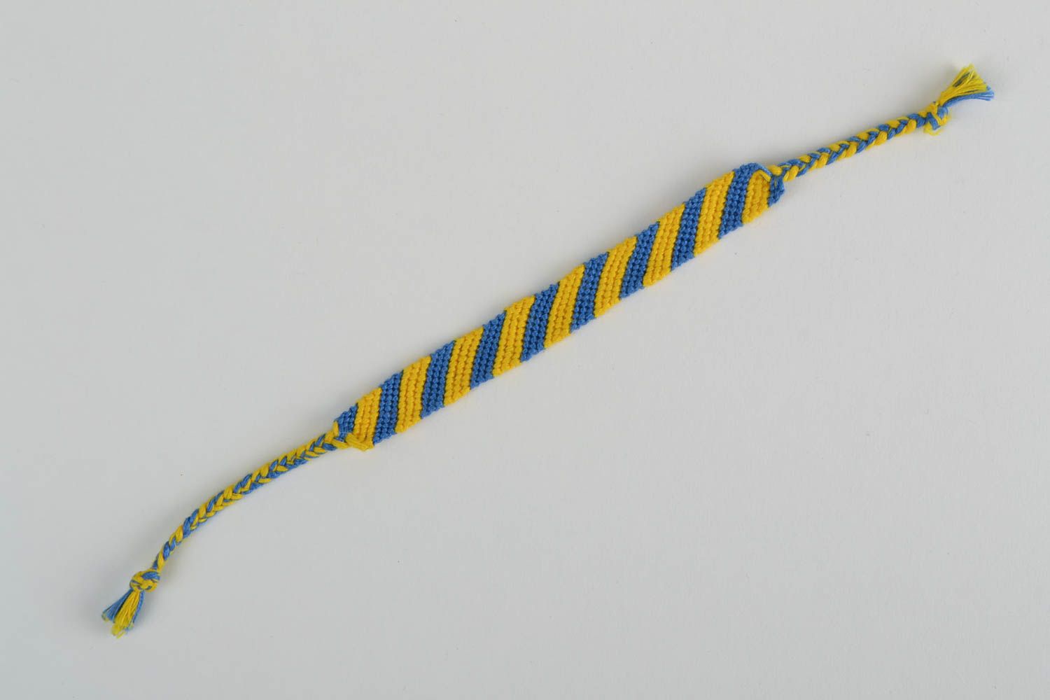 Pulsera de hilos amarilla azul vistosa trenzada artesanal en cordones foto 5
