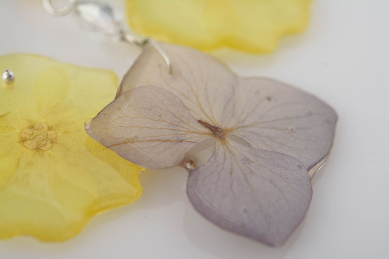 Handmade decorative earrings with primrose and hydrangea petals in epoxy resin photo 3