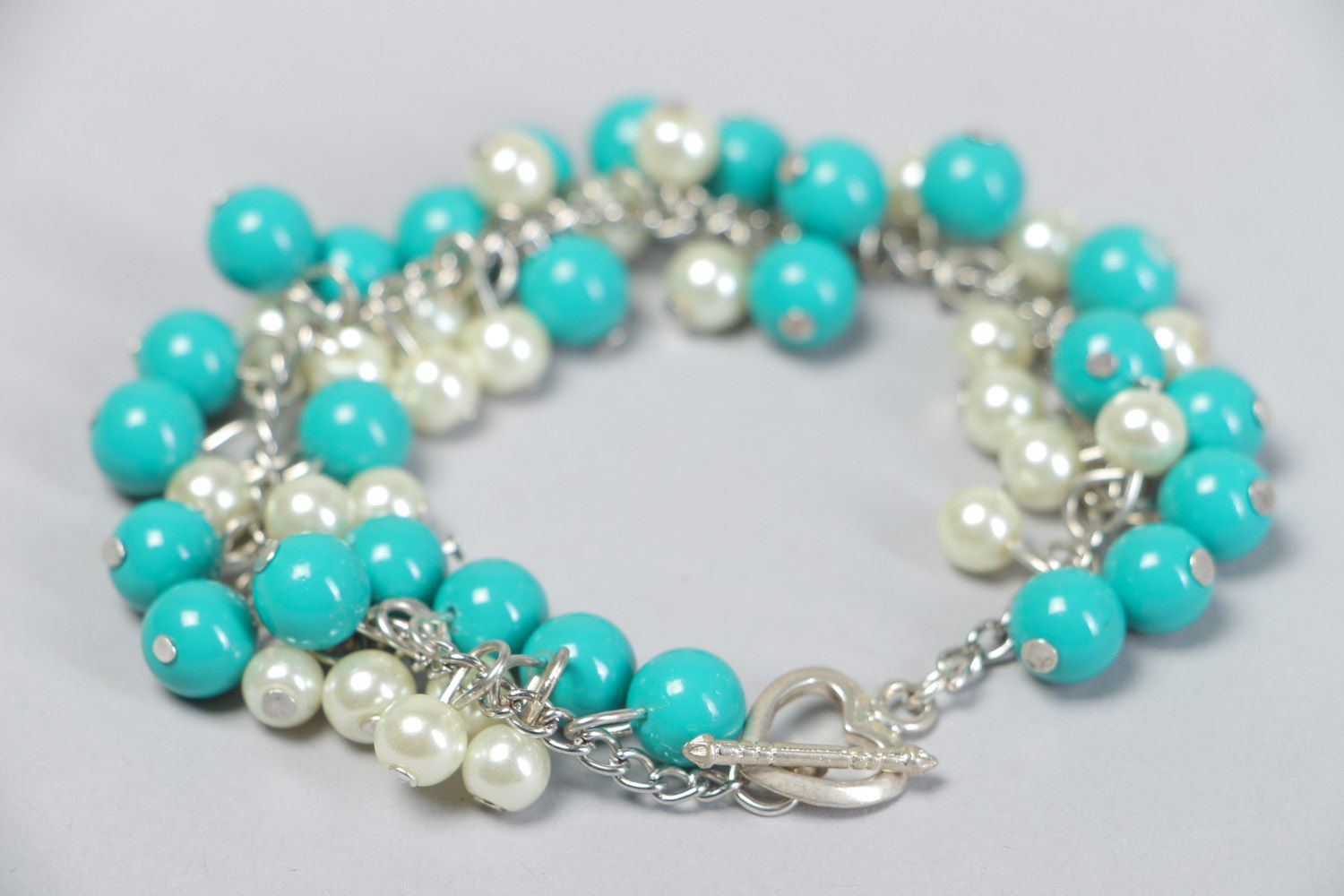 Handmade bright stylish beaded wrist bracelet with charms of turquoise and white colors photo 4