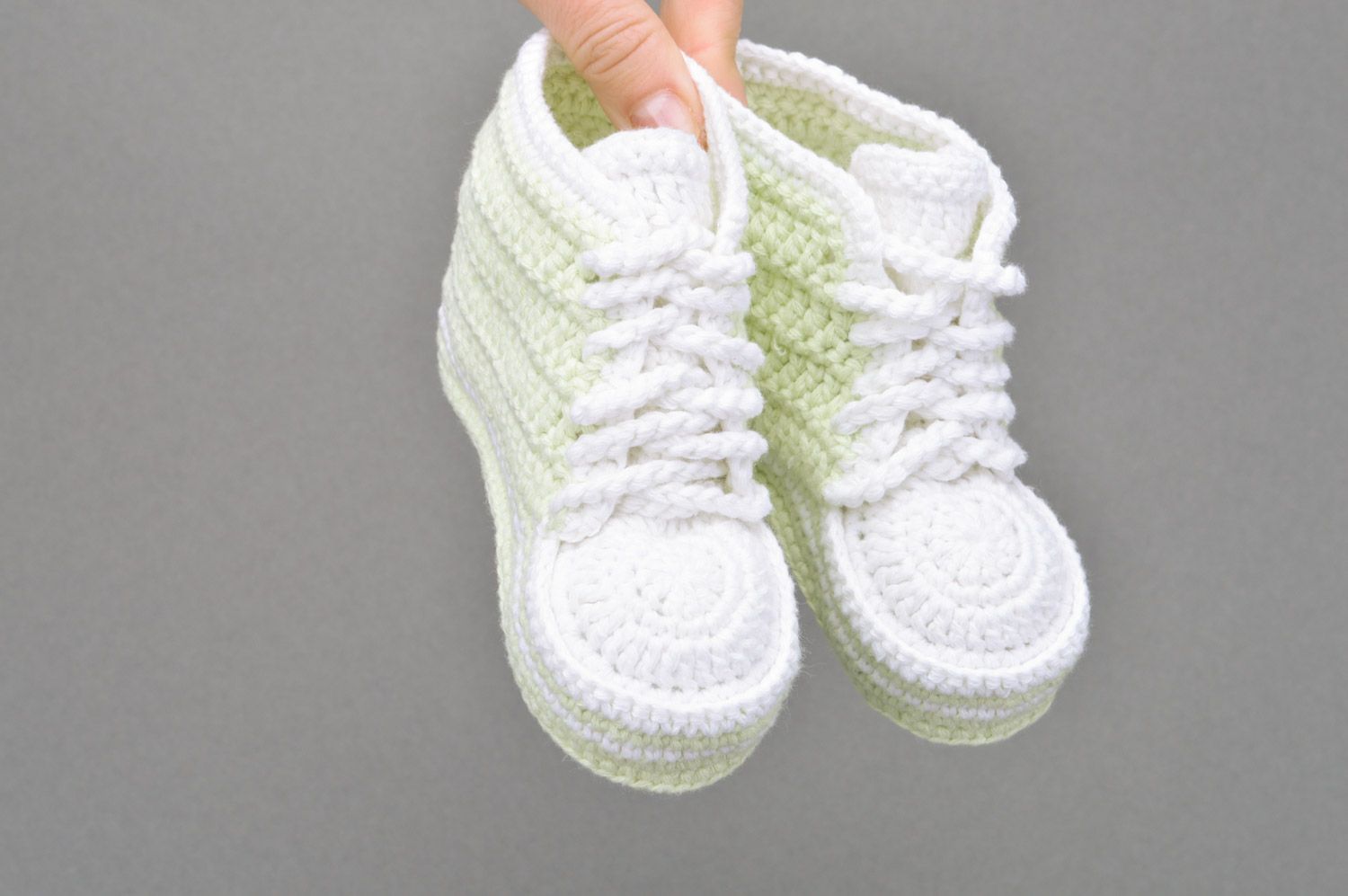 Hellgrüne handgemachte Babyschuhe gehäkelt aus Baumwolle in Form von Sportschuhen foto 3