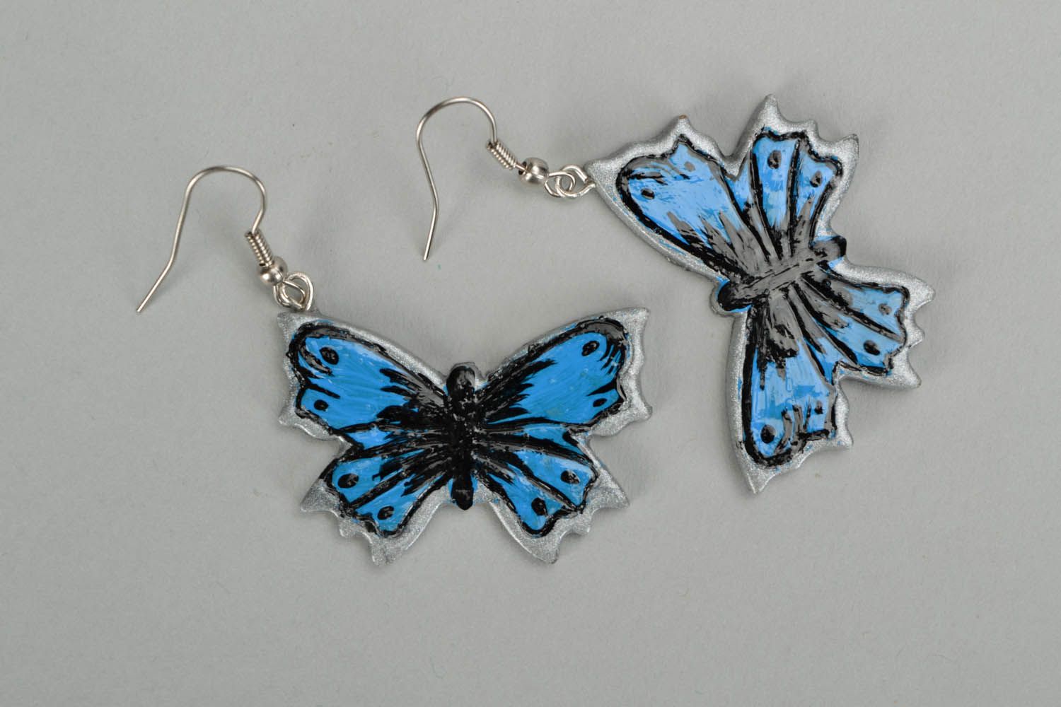 Brincos pingentes prateados feitos de cerâmica plástica na forma de borboletas foto 2