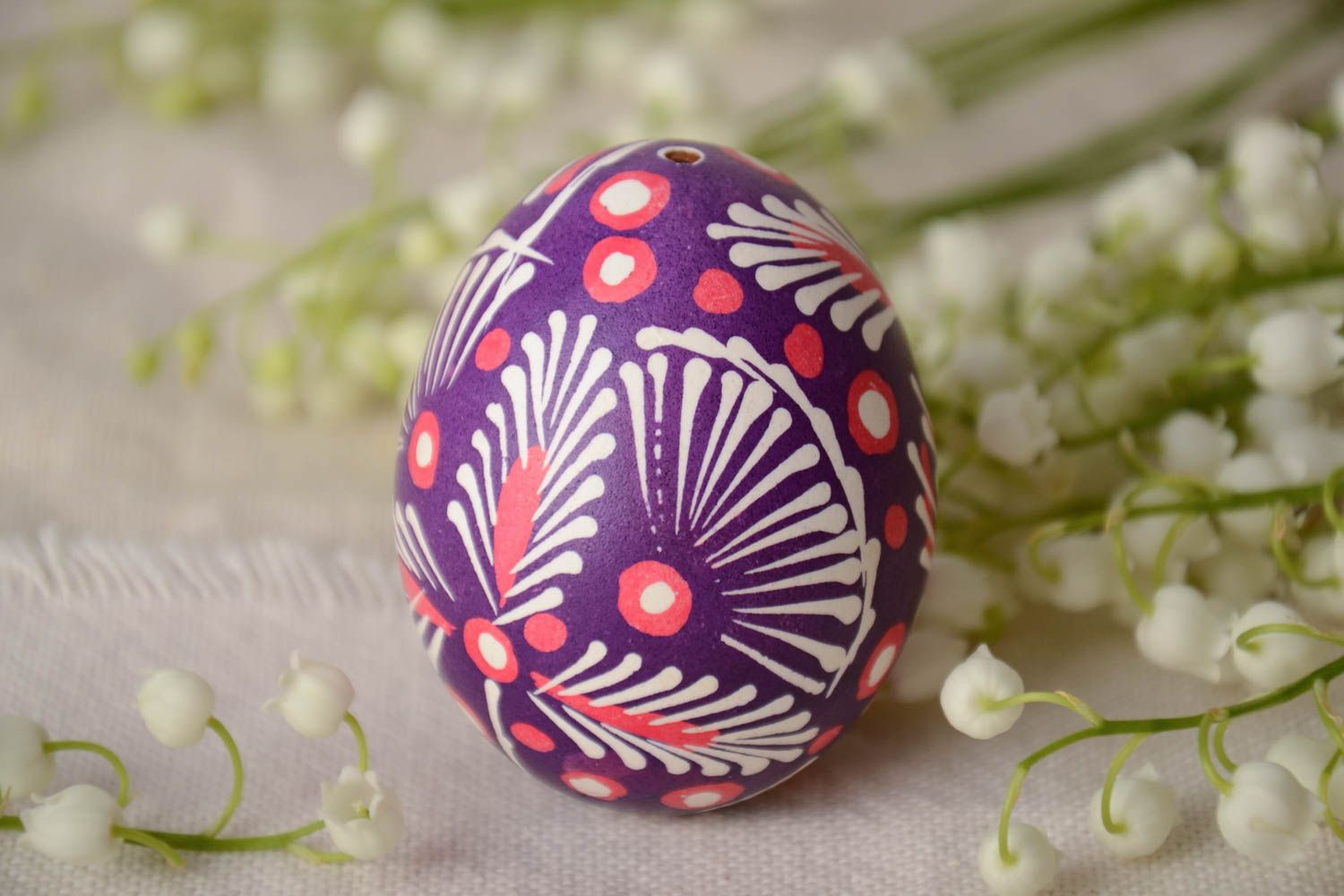 Huevo pintado arteanal en la técnica lemkivska con ornamentos de colores blanco y violeta foto 1