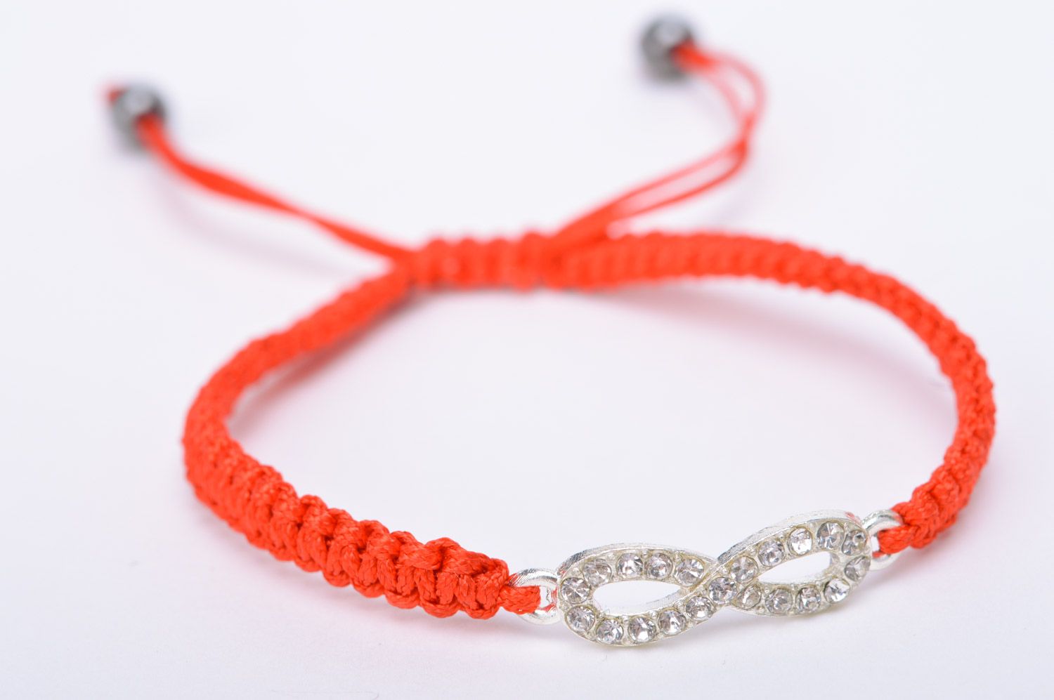 Handmade thin friendship wrist bracelet woven of red threads with infinity sign photo 2