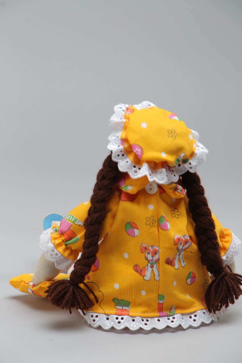 Künstlerische Puppe aus Textil in gelber Kleidung und mit langen Zöpfen handmade foto 4