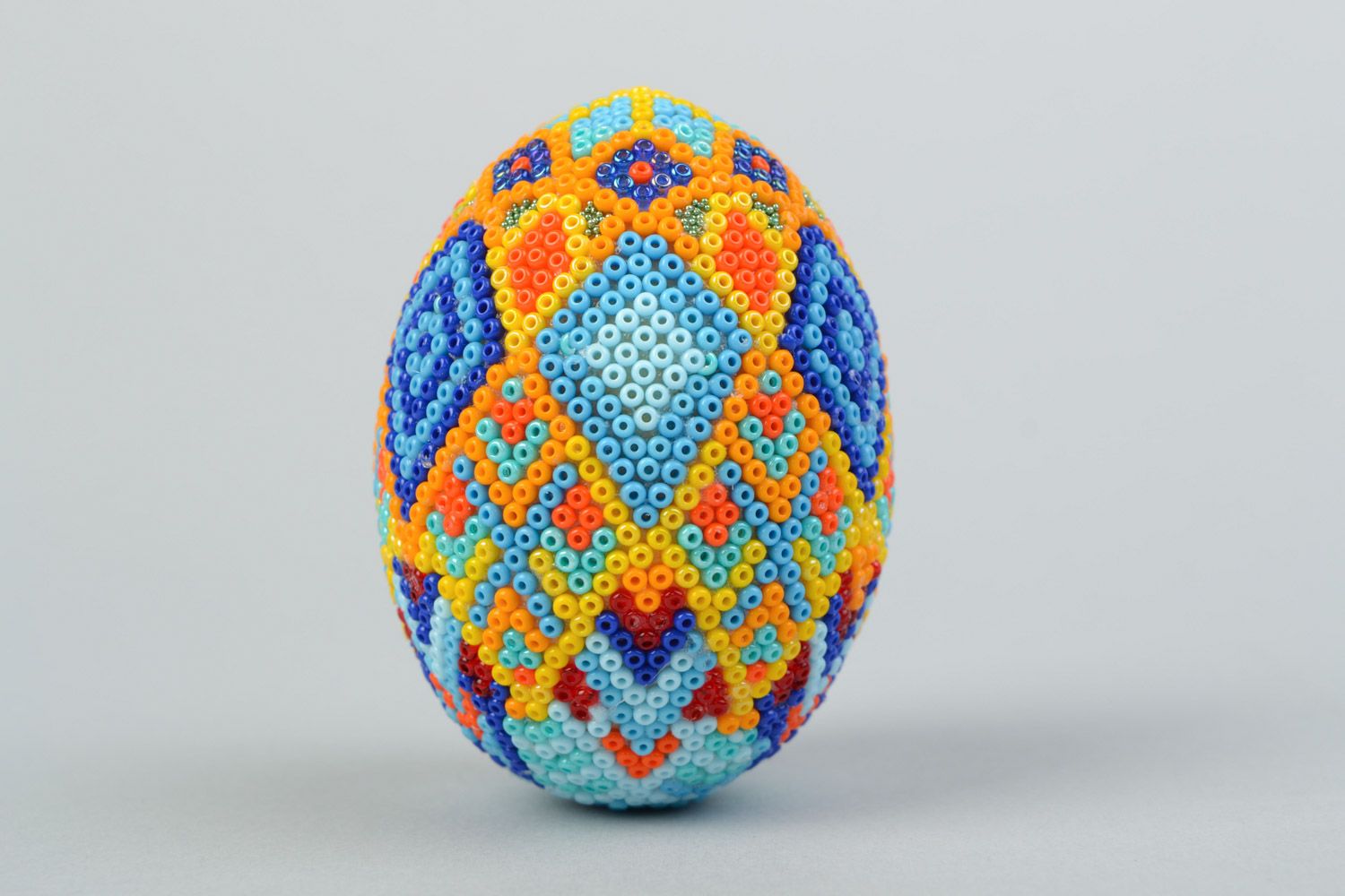 Handmade wooden multicolored Easter egg braided over with beads in Huichol style photo 1