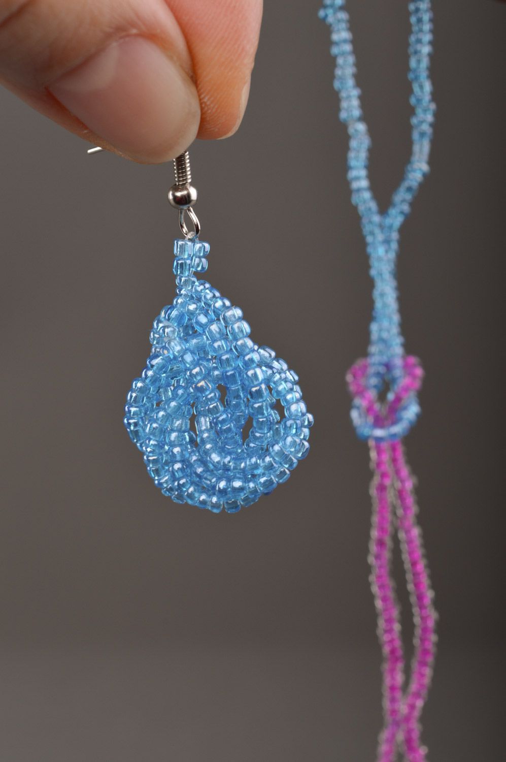 Set of handmade beaded jewelry long earrings and wrist bracelet on blue color photo 3