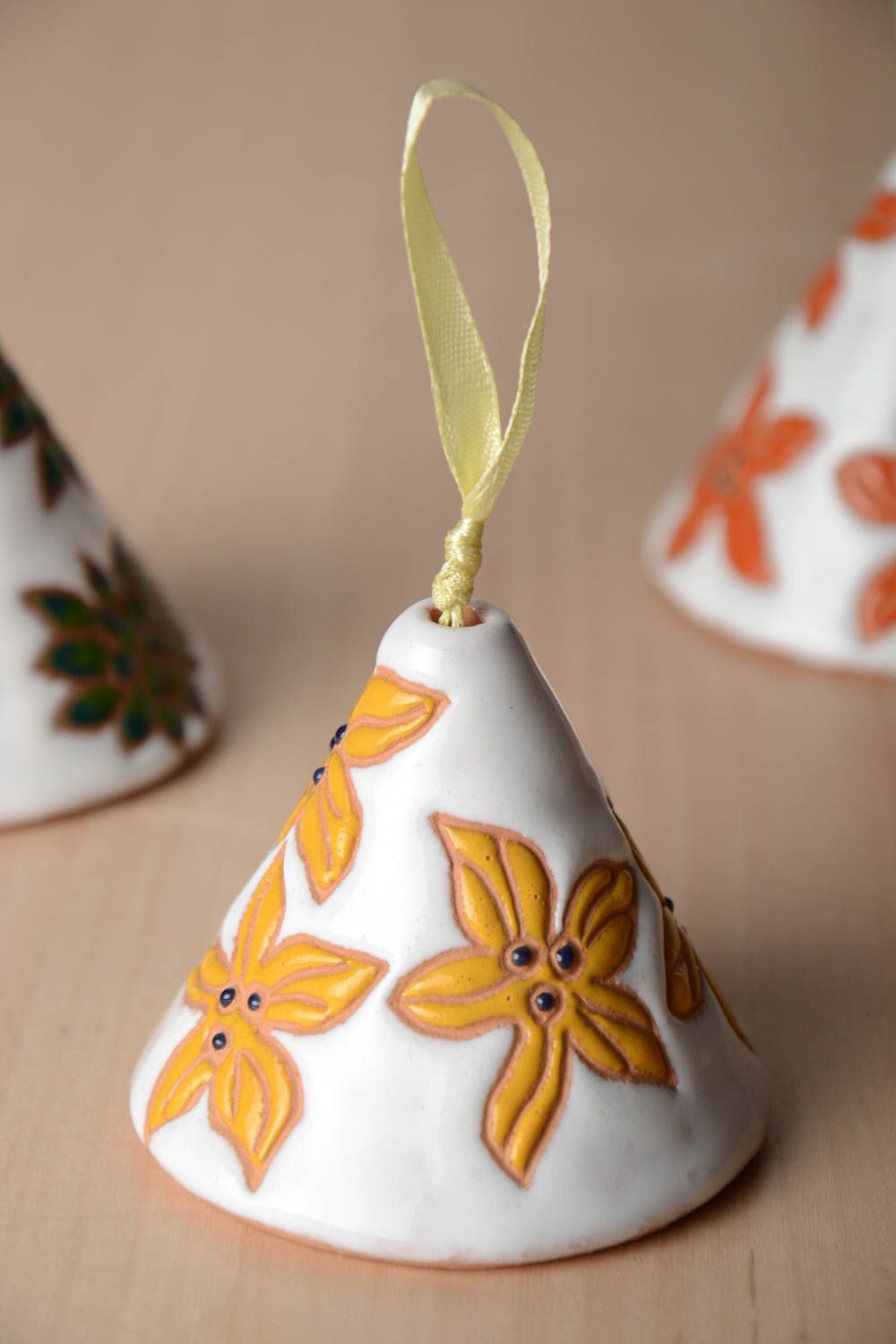 Handmade decorative ceramic bell painted with yellow flowers on white background photo 1