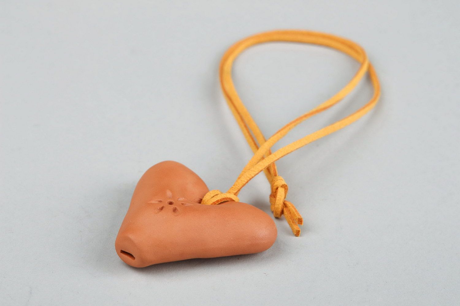 Un colgante silbato en la forma del corazón, un instrumento musical y un juguete para los niños. foto 3