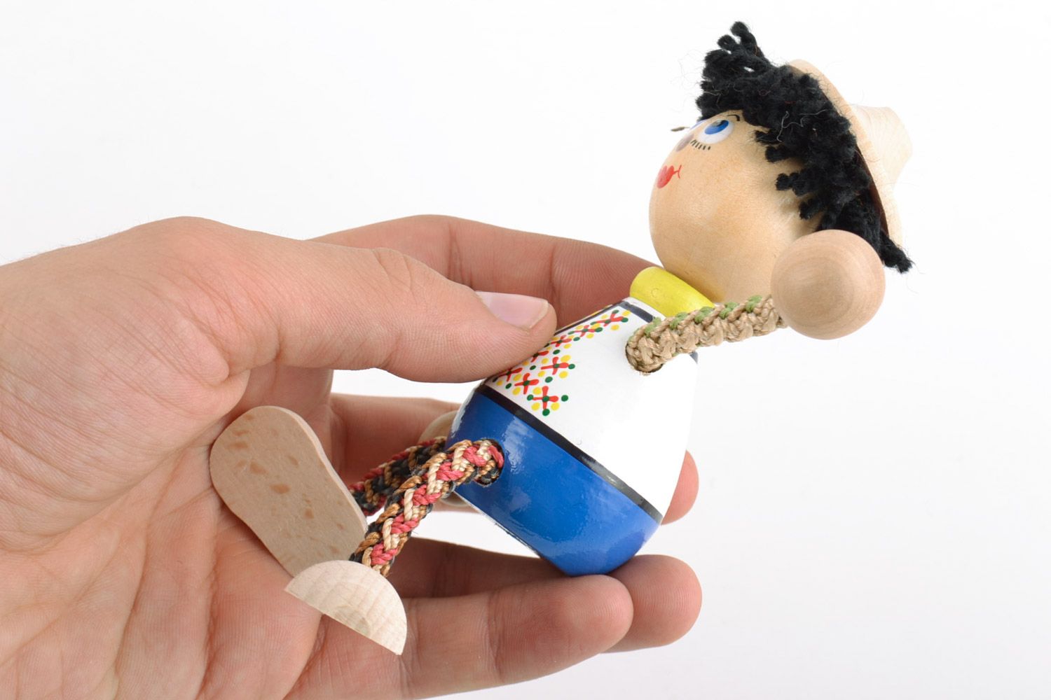 Schönes bemaltes handgemachtes Öko Spielzeug aus Holz Junge in Ethno Kleidung foto 2