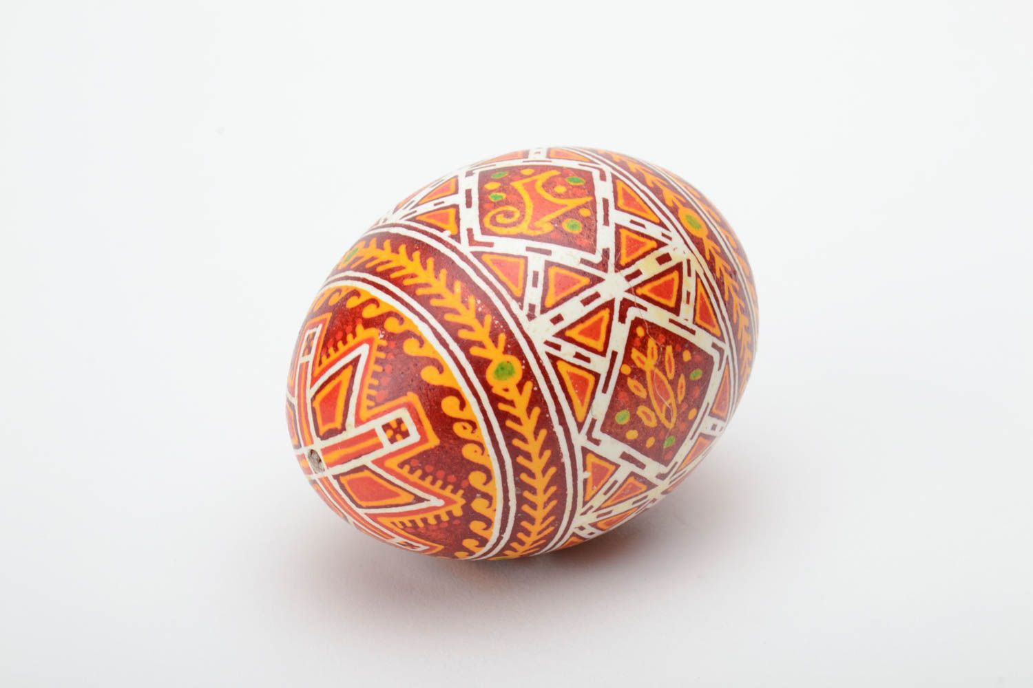 Handmade decorative yellow and red Easter egg painted with wax with deer image photo 2
