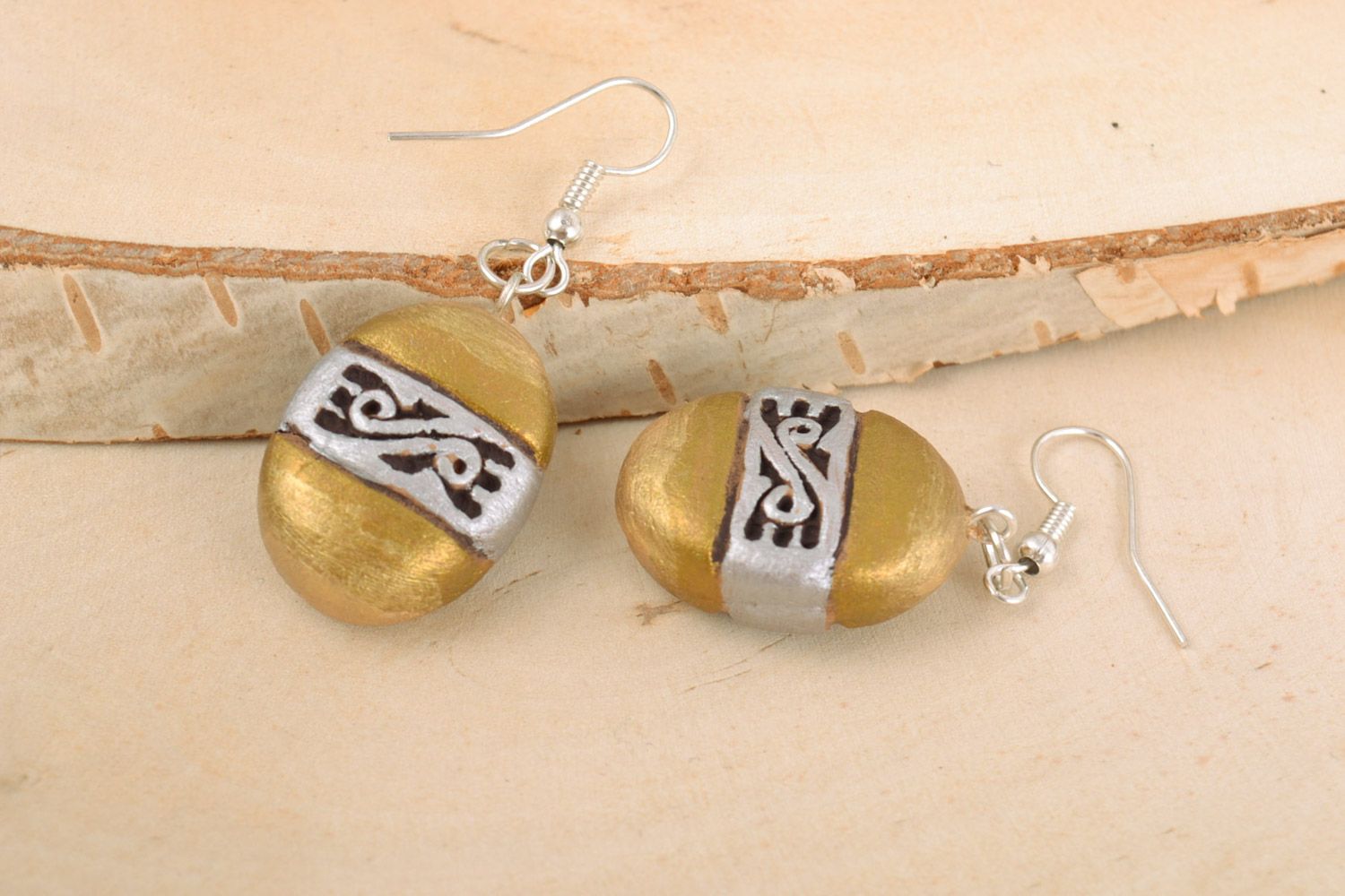 Unusual handmade ceramic dangling earrings of oval shape and golden color photo 1