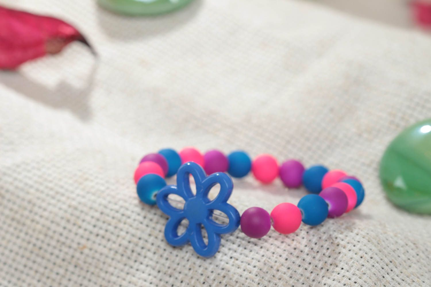 Colorful homemade children's wrist bracelet with plastic beads and flower photo 1