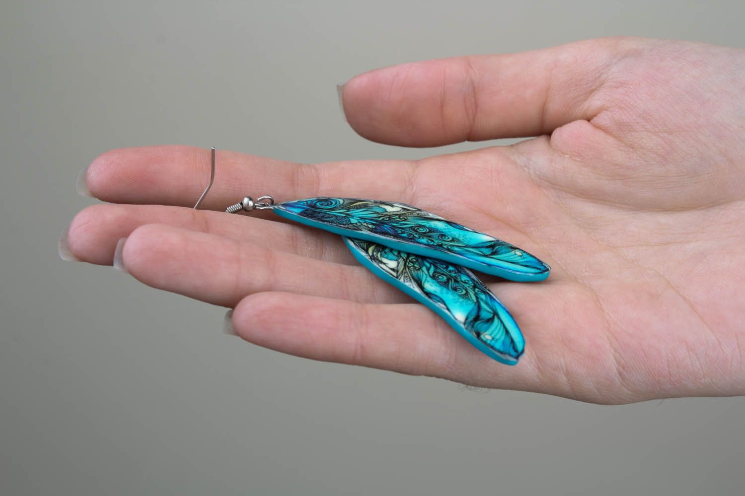 Belos brincos feitos de cerâmica plástica na forma de penas azuis brilhantes Penas foto 1