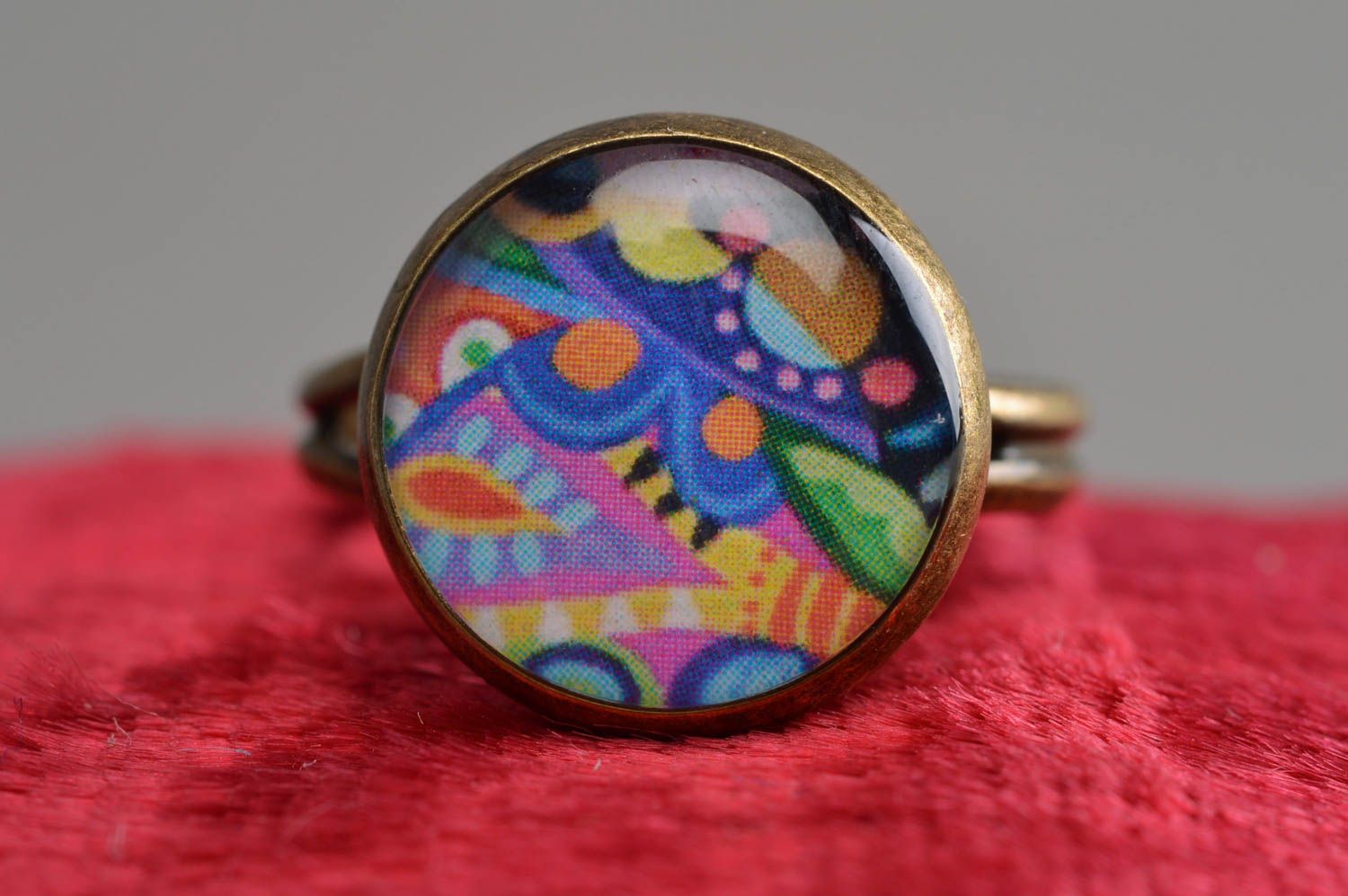 Handmade decoupage jewelry ring in epoxy resin with bright pattern on metal basis photo 2