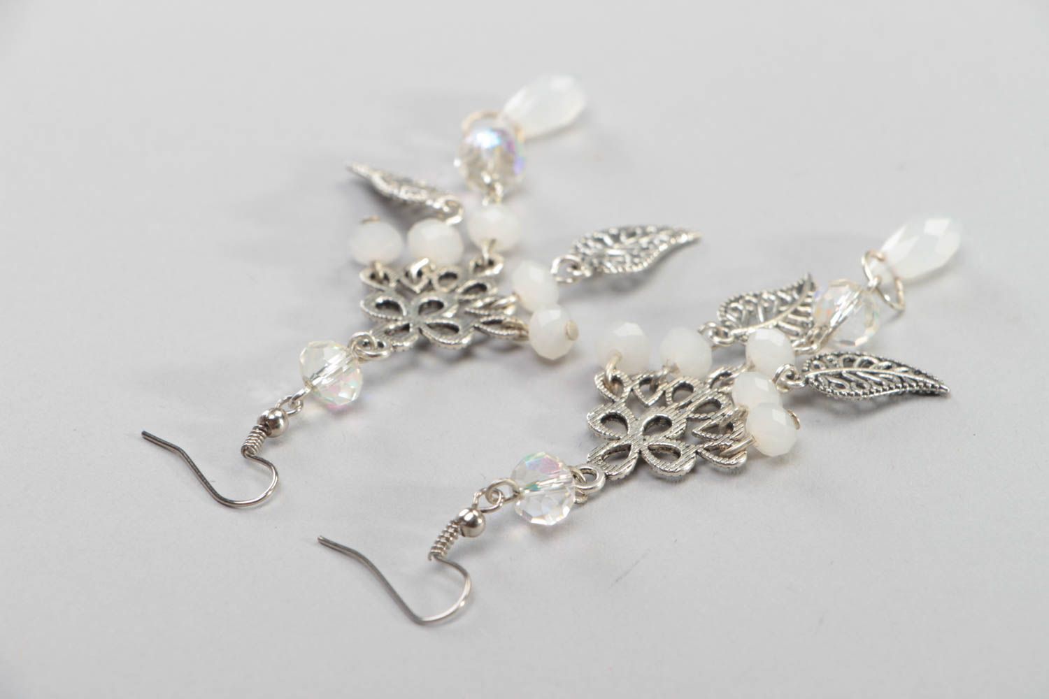 Handgemachte Blumen Ohrringe mit Anhängern aus Stahl und weißen Glasperlen  foto 4