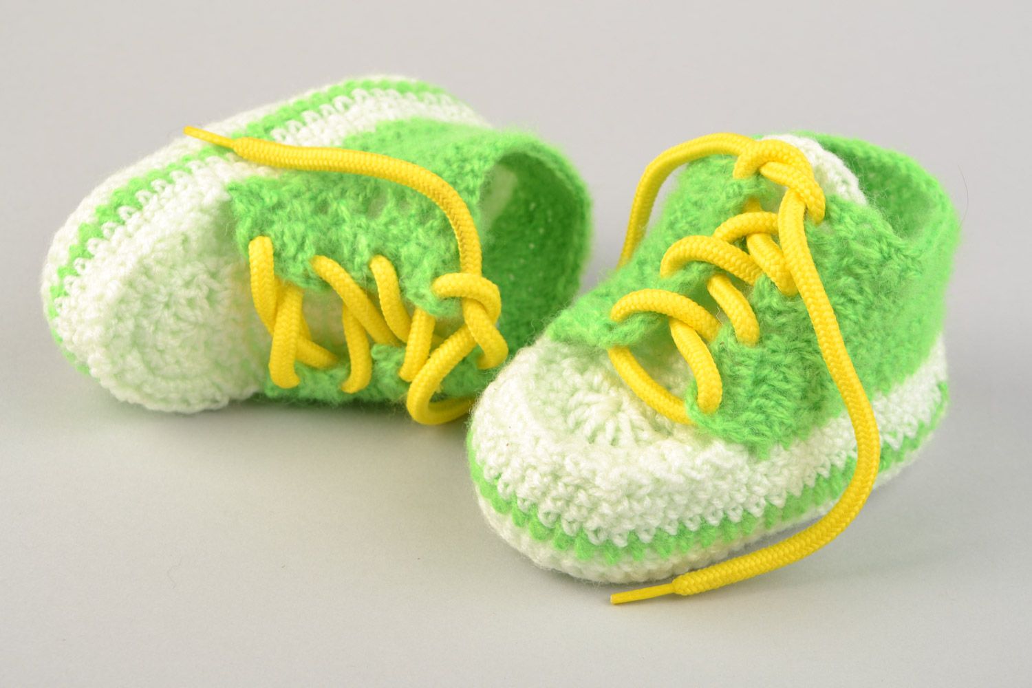 Handgemachte Babyschuhe gehäkelt aus Acrylfäden in Grün und Weiß mit Schnürsenkel  foto 1