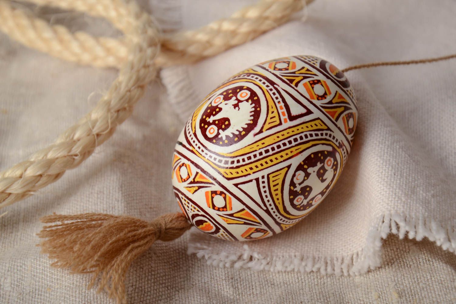 Homemade painted Easter egg with tassel and patterns created using waxing technique photo 1