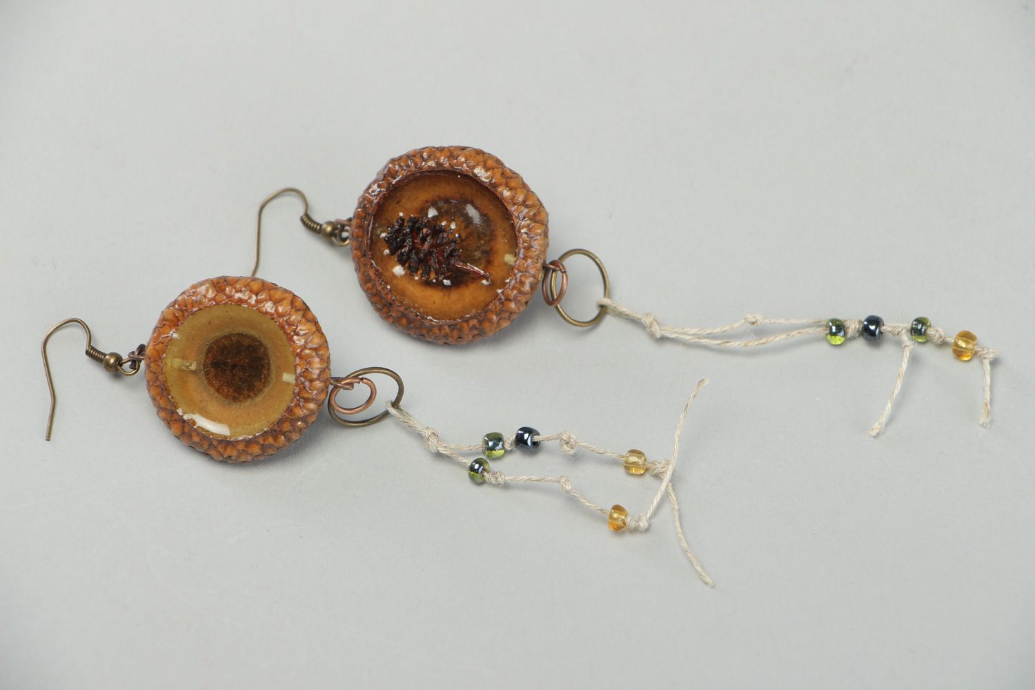 Handmade dangle earrings made of natural materials coated with epoxy resin photo 1
