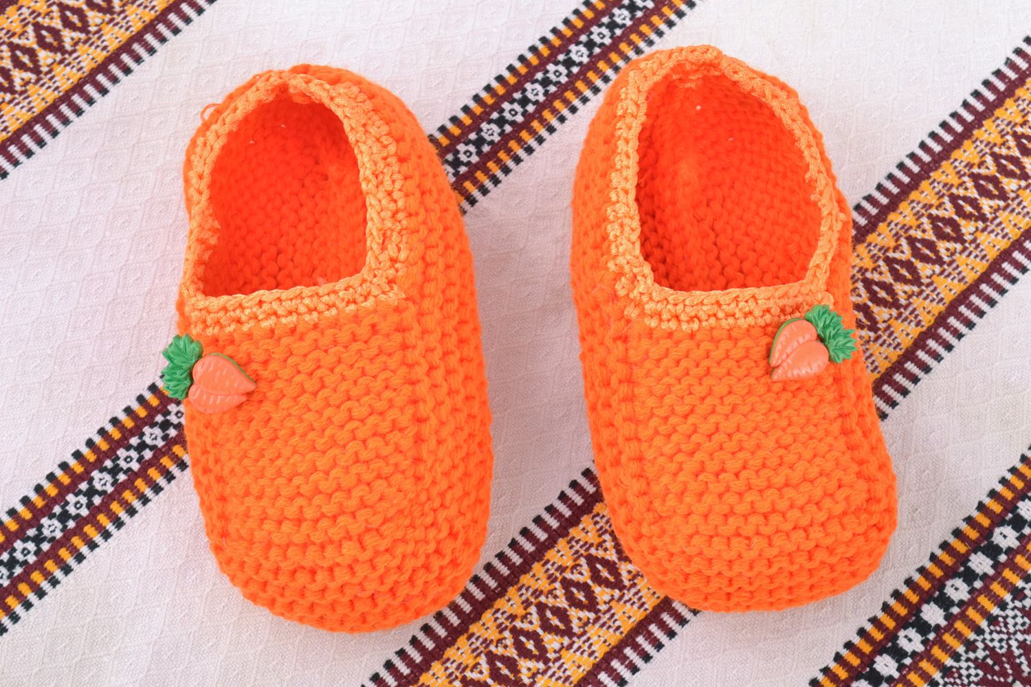 Orangefarbige handgemachte Babyschuhe aus Wolle für Mutter von kleinem Kind  foto 1