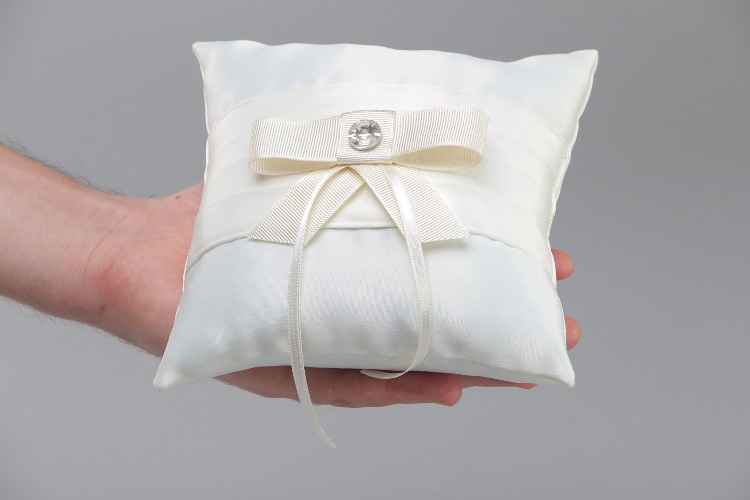 Tender handmade wedding ring pillow sewn of ivory-colored satin fabric with bow photo 5