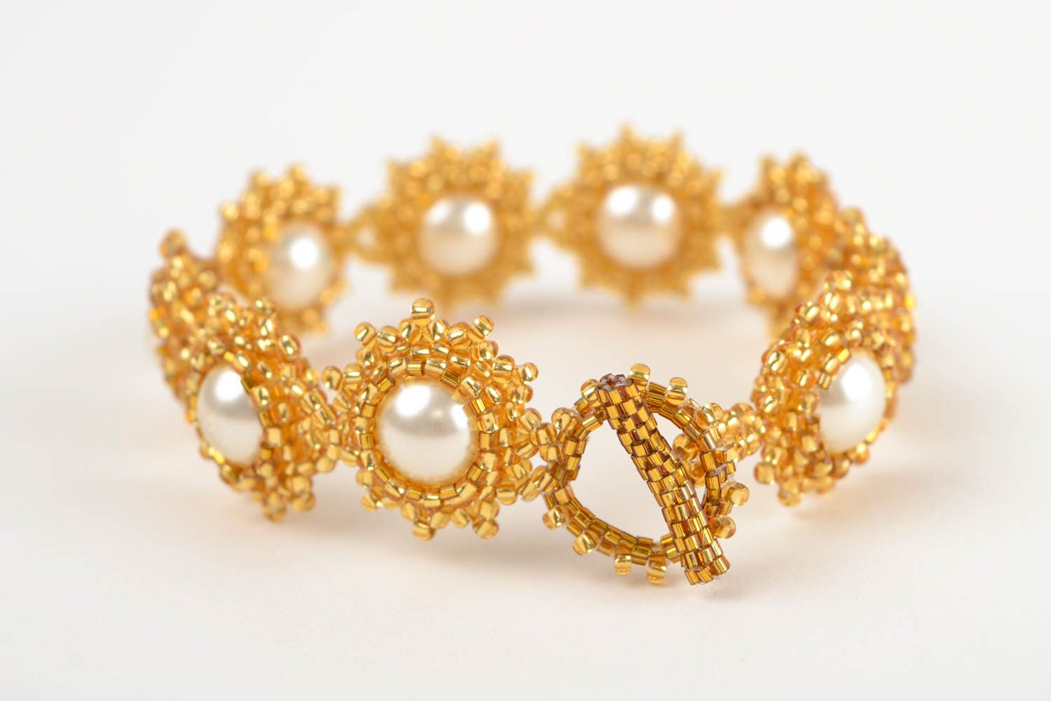 Beaded bracelet in the shape of flowers in gold and white colors photo 4