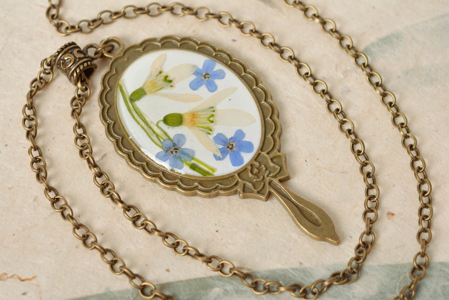 Colgante ovalado con flores secas en resina epoxi en cadena artesanal foto 2