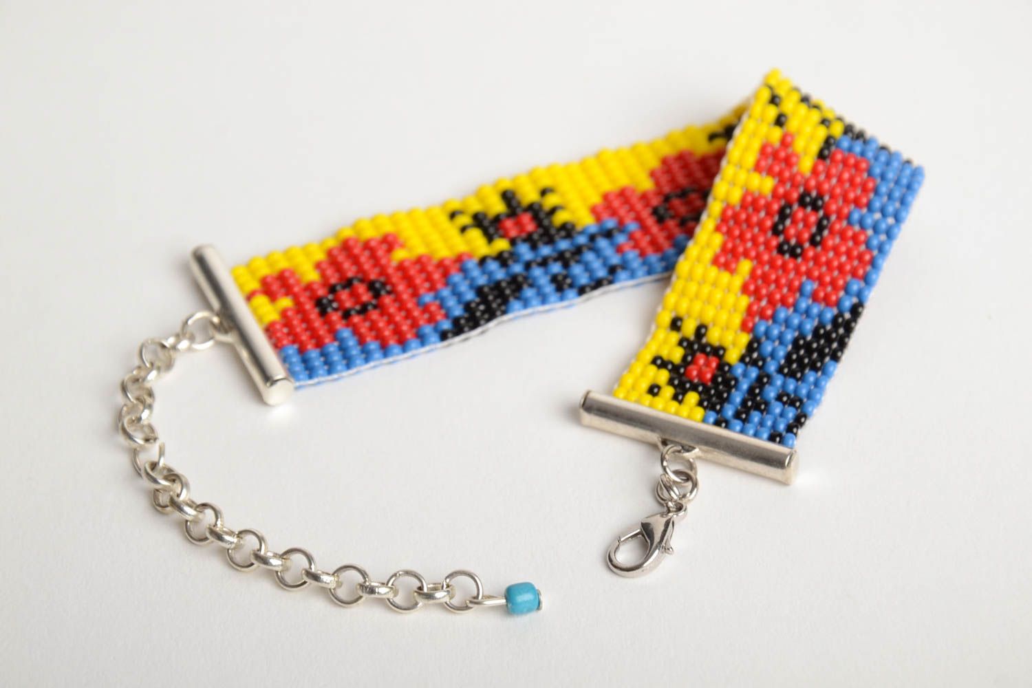 Handmade blue and yellow bead woven wrist bracelet with red poppy pattern