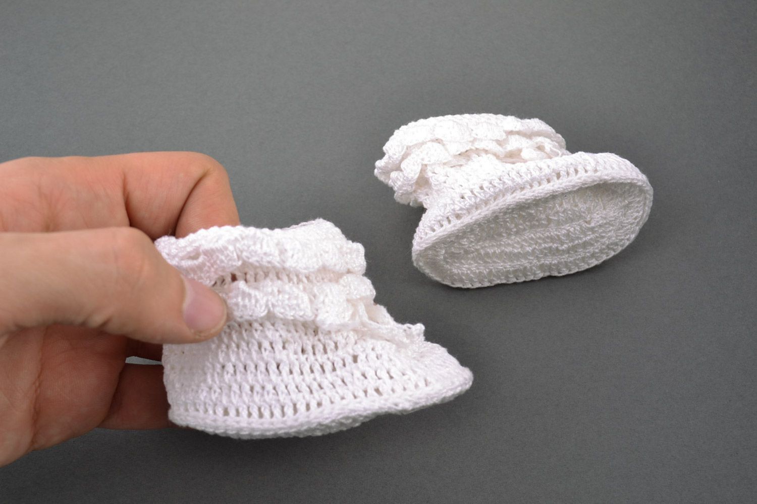 White handmade baby booties knitted of wool and cotton in the shape of shoes photo 3