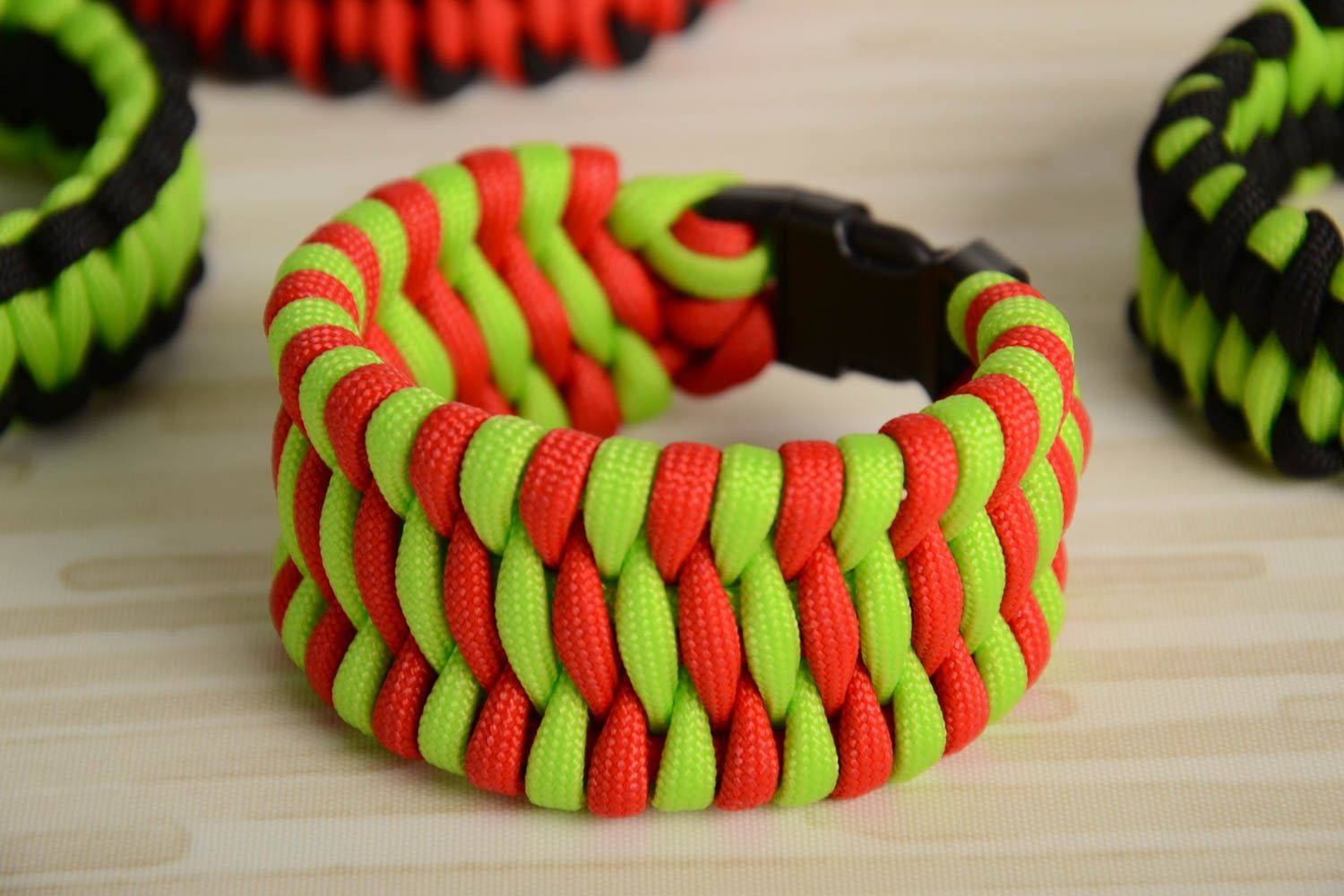 Handmade wrist survival bracelet woven of bright paracords with plastic fastener photo 1