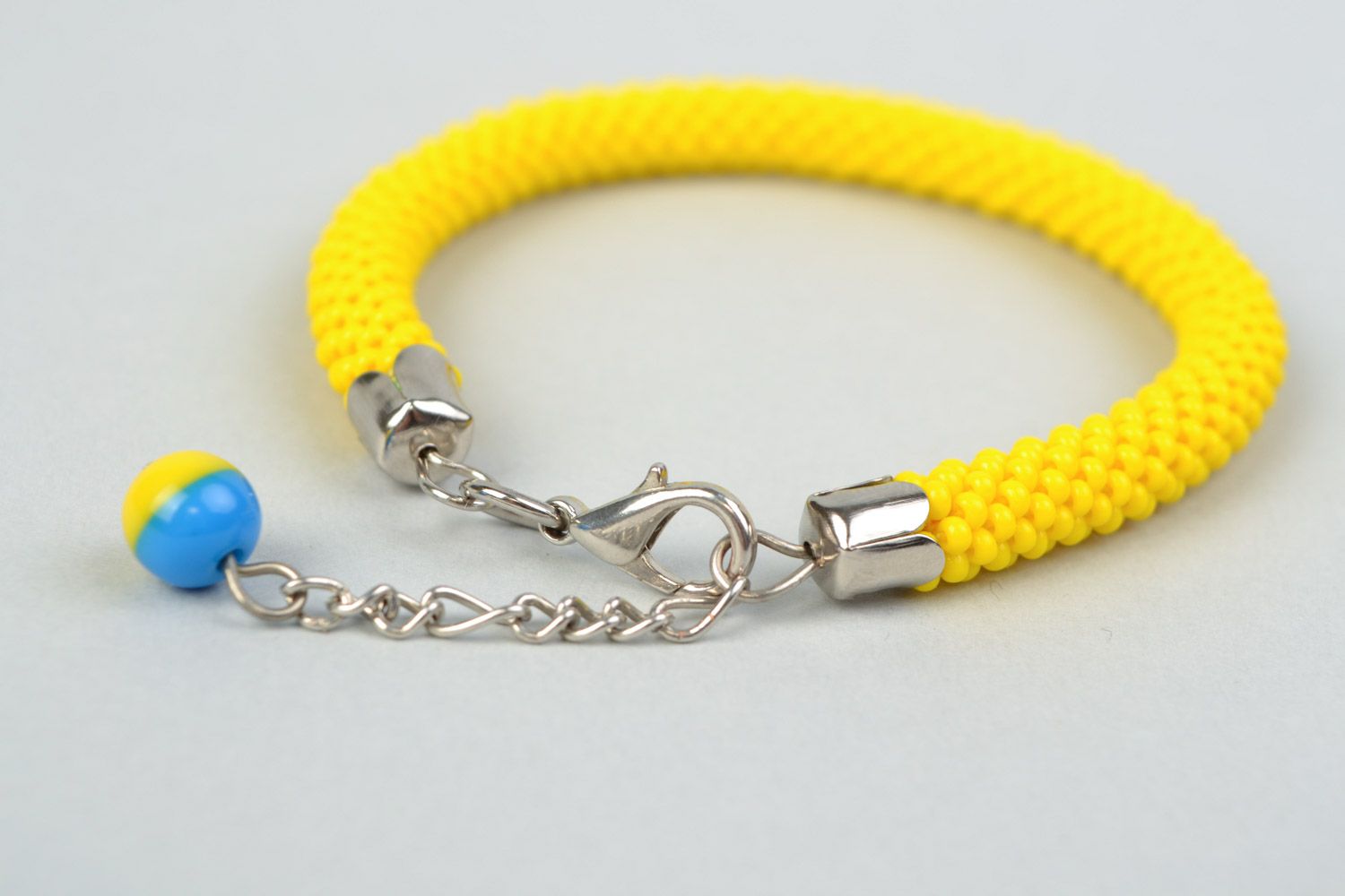 Handmade cord bracelet crocheted of bright yellow Czech beads with blue charm photo 3